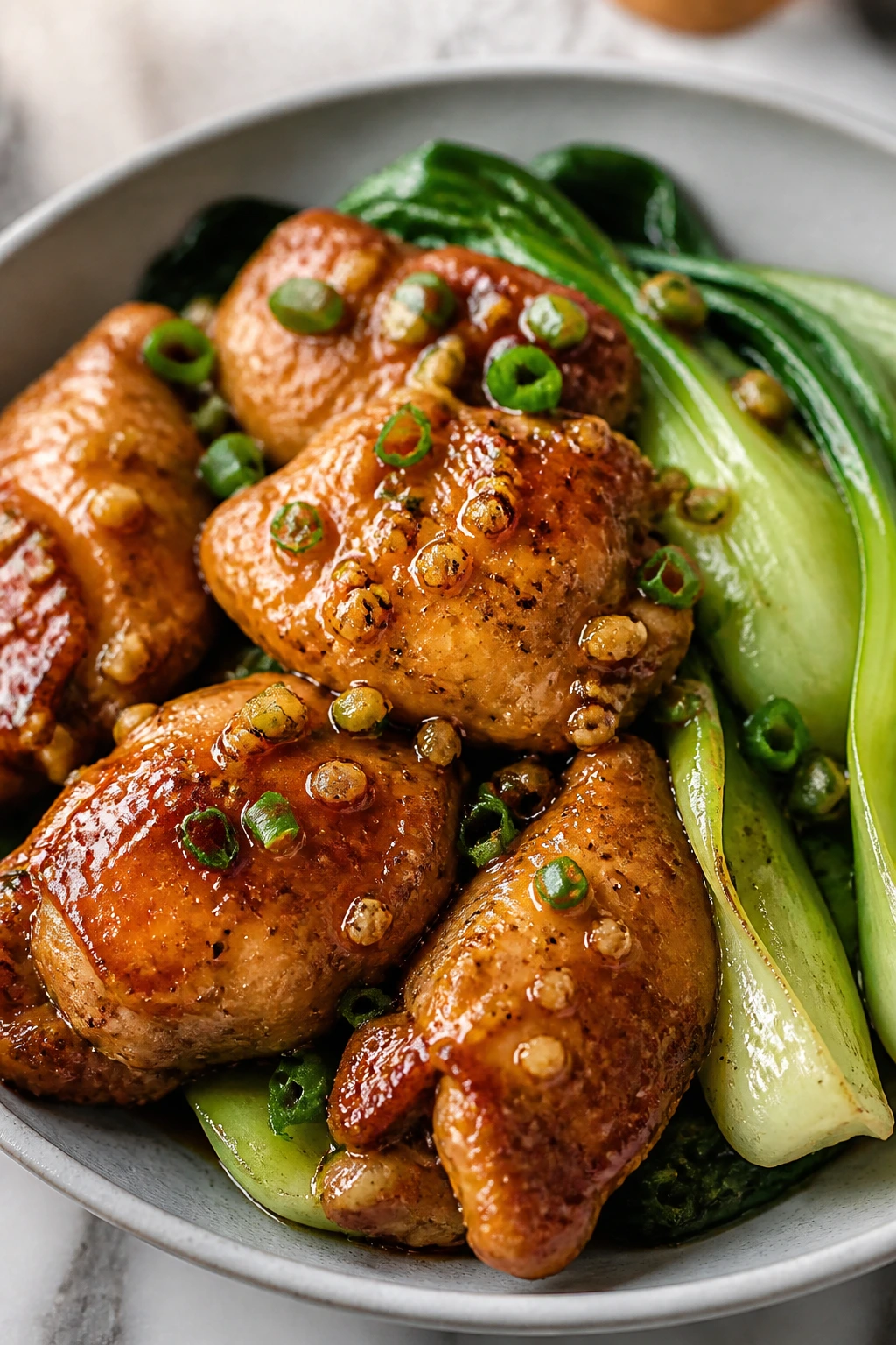 Close-up of garlic chicken with bok choy on a plate in a home kitchen