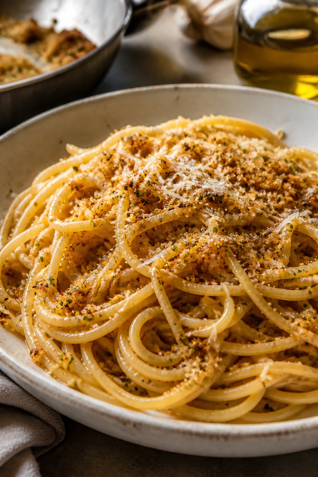 Garlic spaghetti with toasted breadcrumbs in a warm kitchen setting