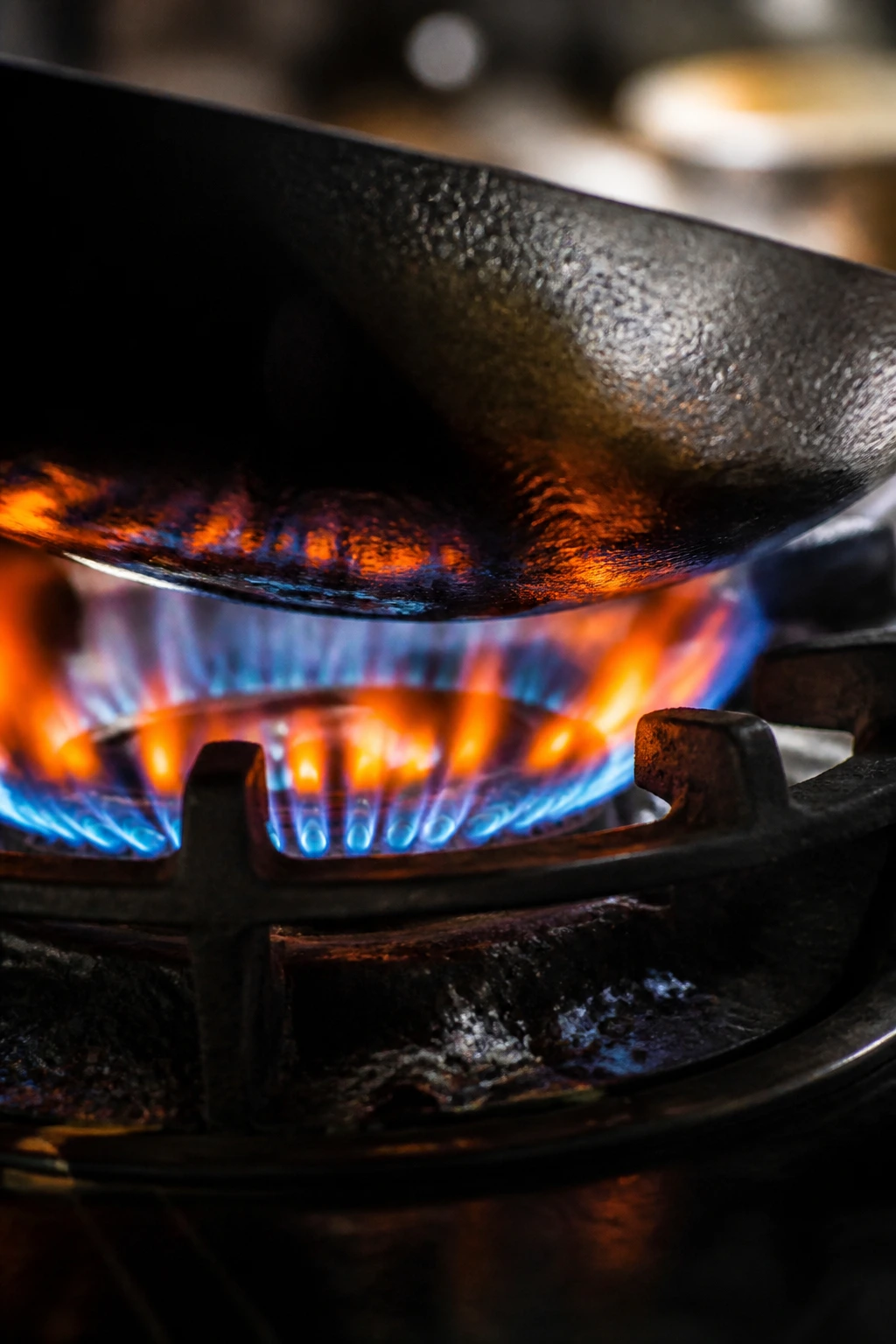 Blue-orange gas flame under a wok on a stove