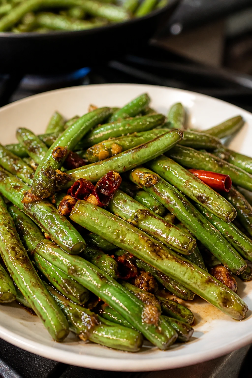 Close-up of blistered green beans with garlic on a plate