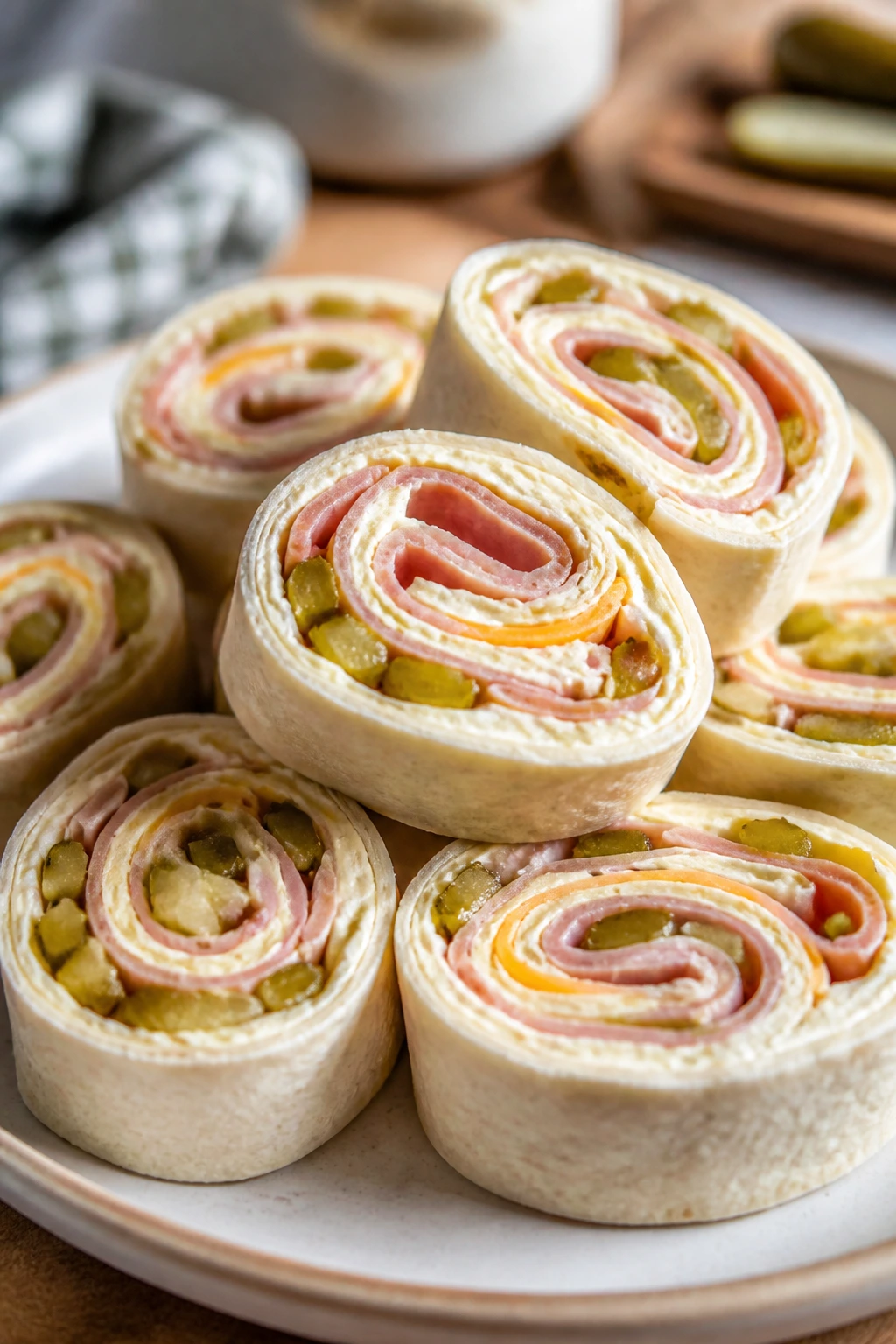 Roll-up slices showing ham, cheese, and pickles on a plate