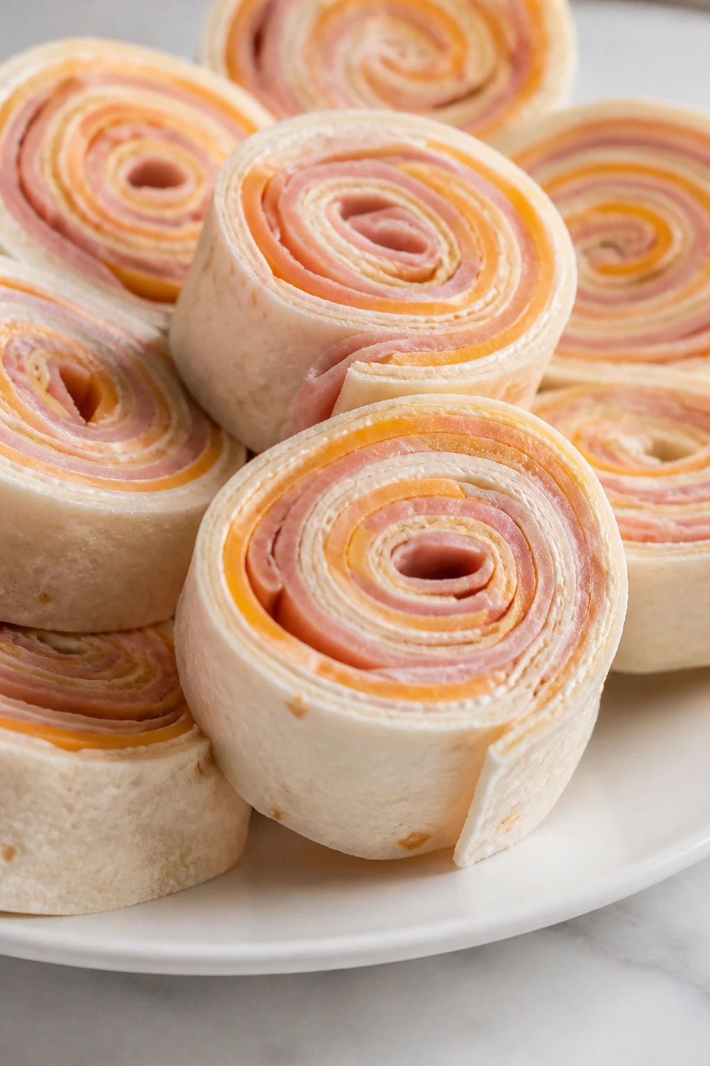 Close-up of ham and cheese pinwheels on a plate
