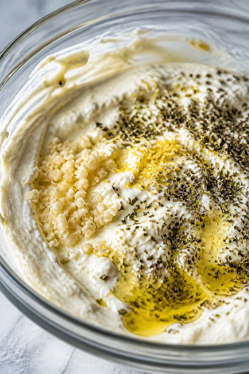 Creamy yogurt marinade with garlic and lemon zest in a bowl