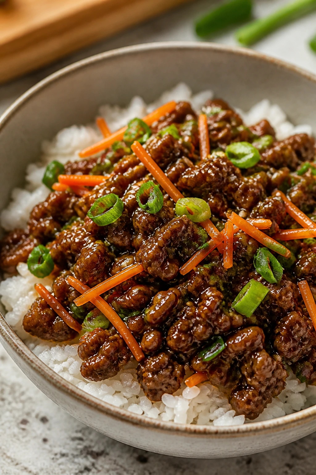 Close-up of Korean beef over rice with sesame oil glaze and green onions