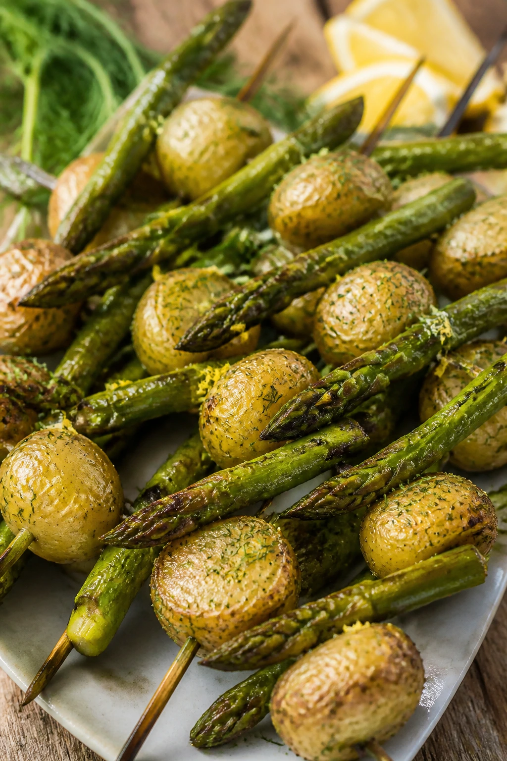 Close-up of Lemon Dill Asparagus and Potato Skewers on a rustic board