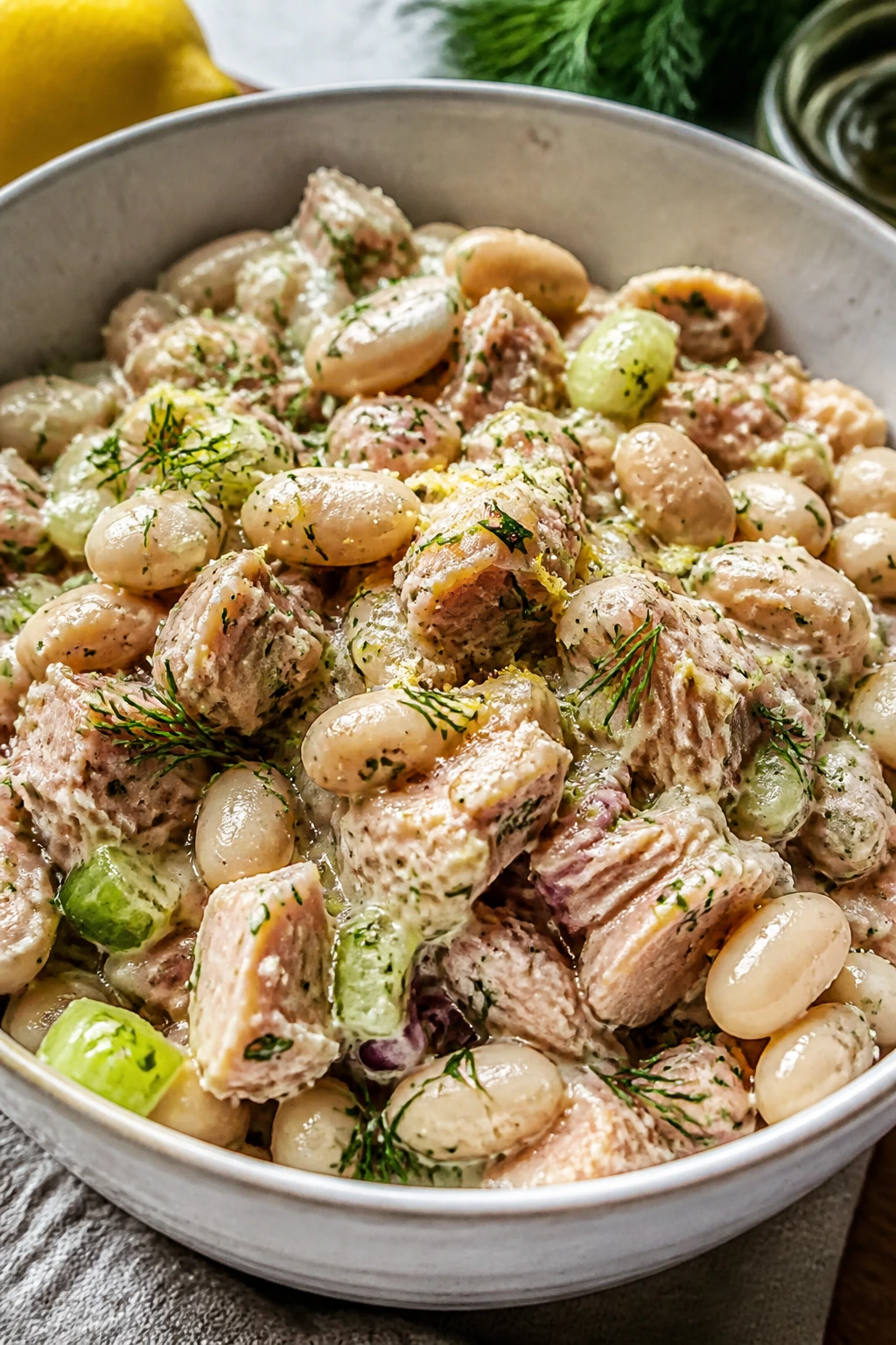 Tuna and white beans in lemon-dill dressing in a rustic bowl