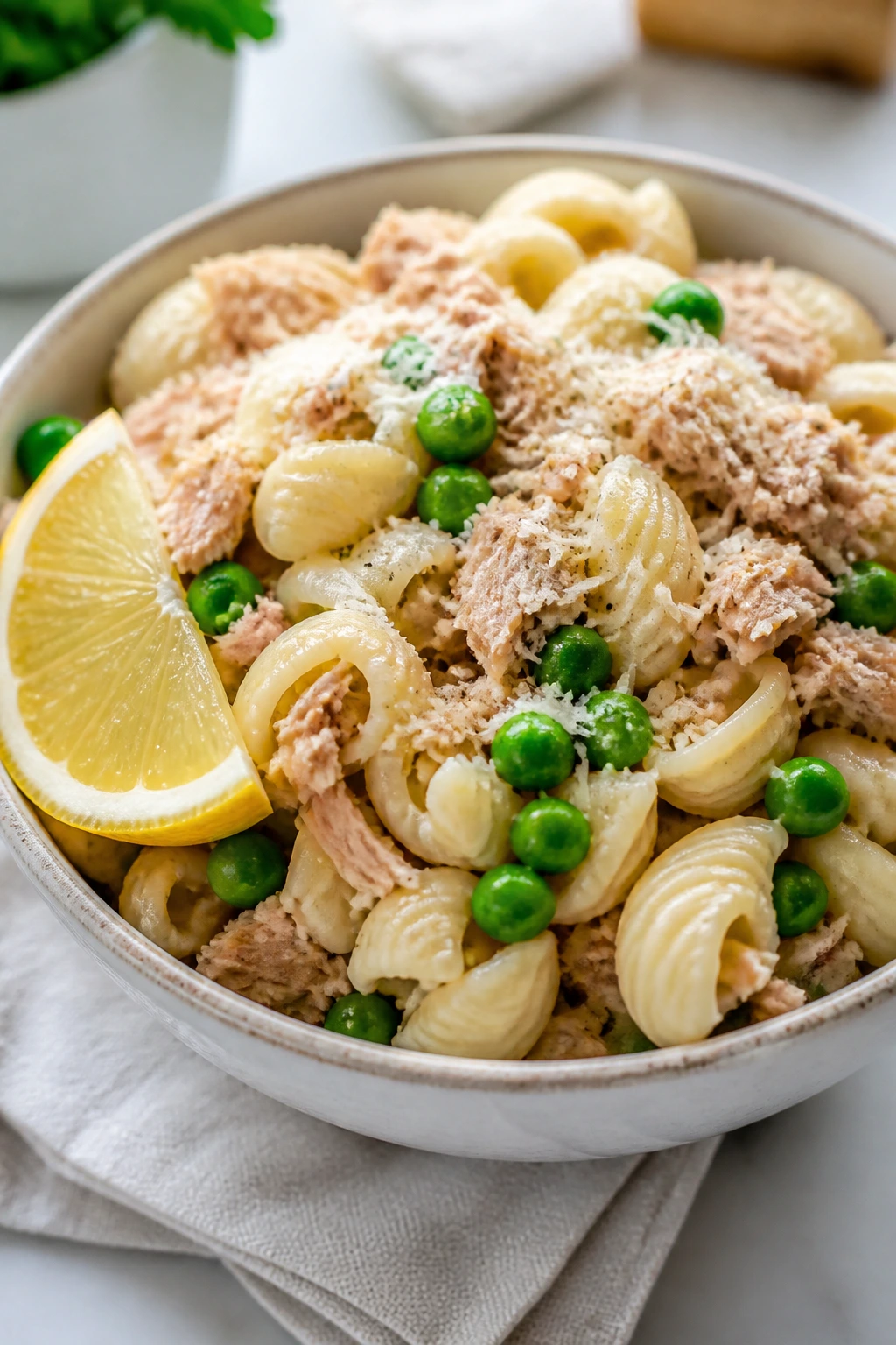 Cold lemon tuna pasta with peas and parmesan in a bowl