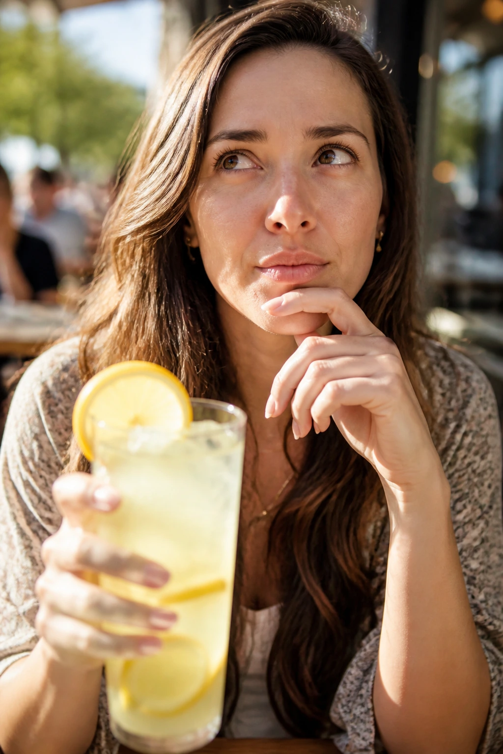 Real woman with lemonade in sunlit cafe