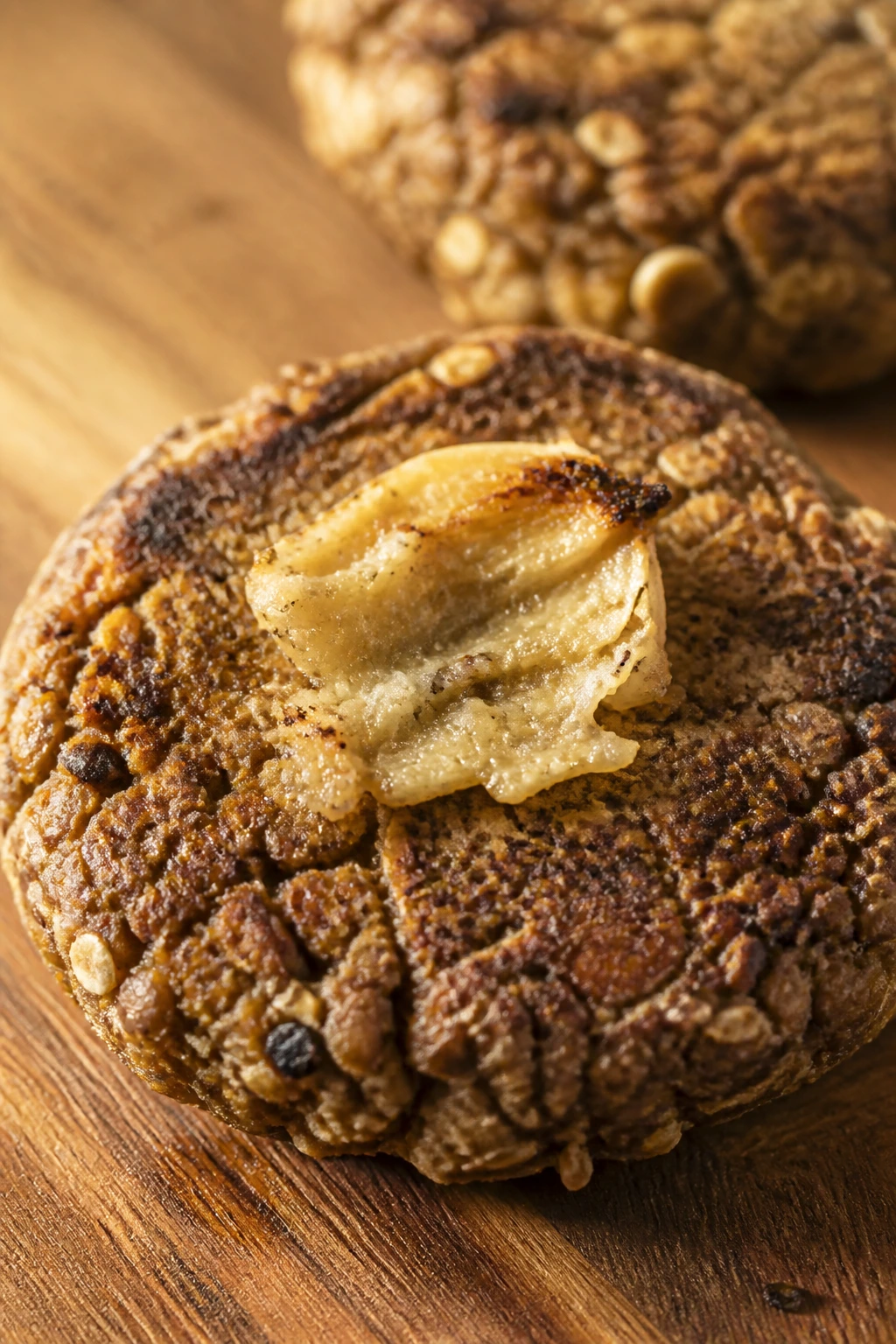 Lentil burger patty with oats and roasted garlic on wooden board