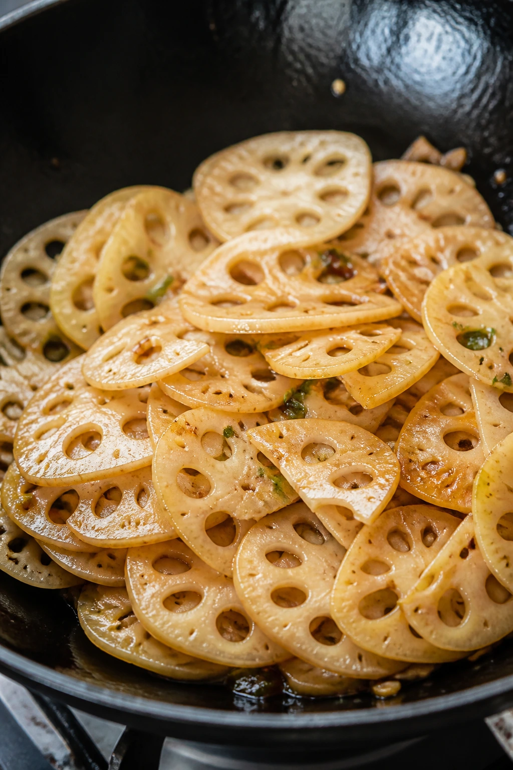 Close-up of Stir-Fried Lotus Root slices in a pan