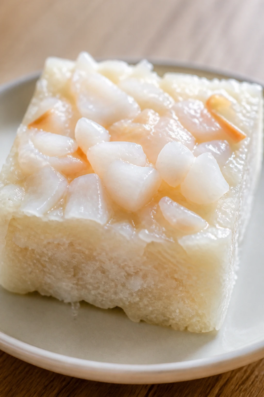 Close-up of lychee coconut sticky rice cake topped with lychees