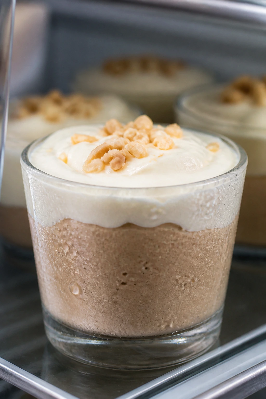Mousse cup with glossy frosting and condensation on glass