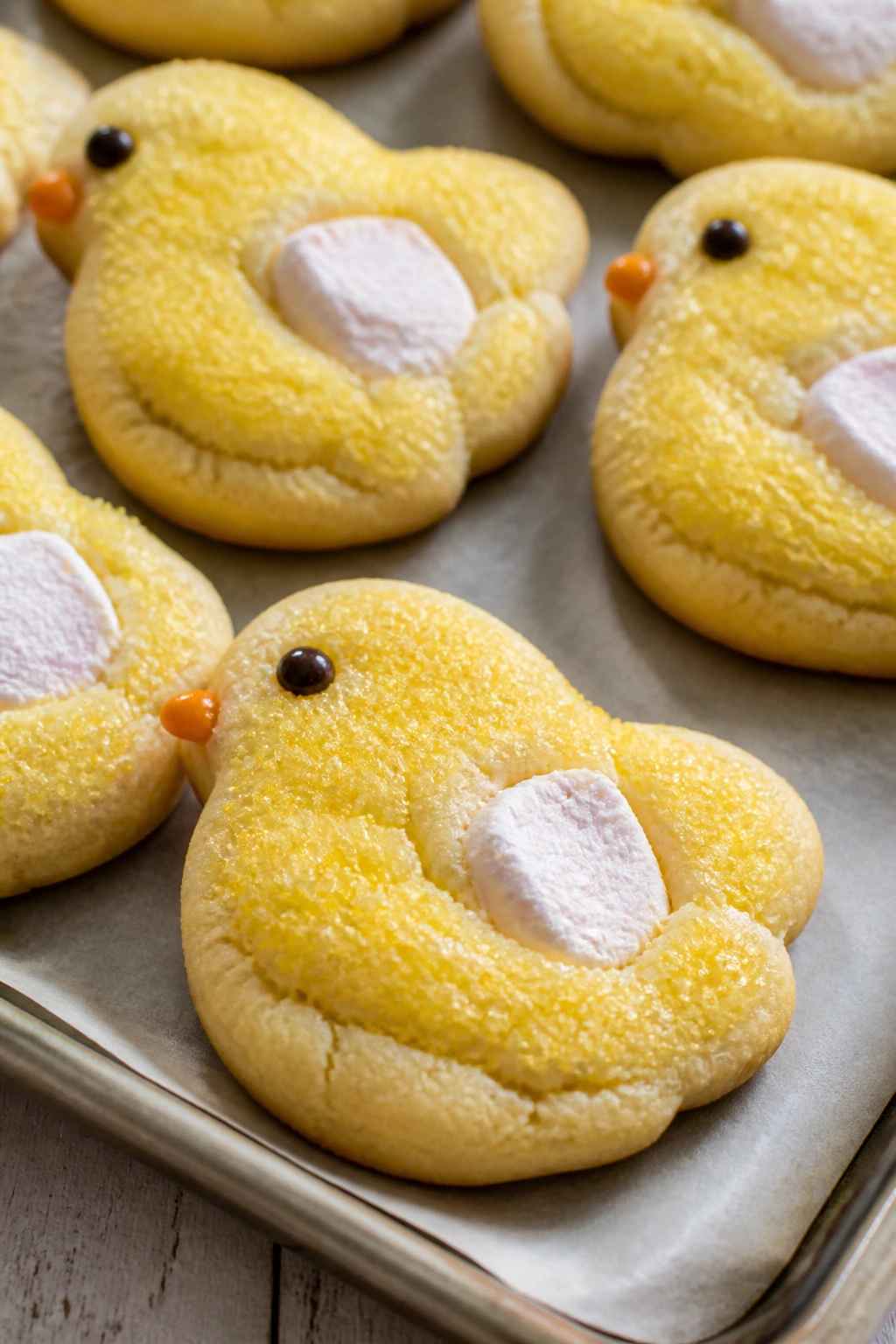 Close-up of marshmallow chick cookies with yellow sugar on a baking sheet