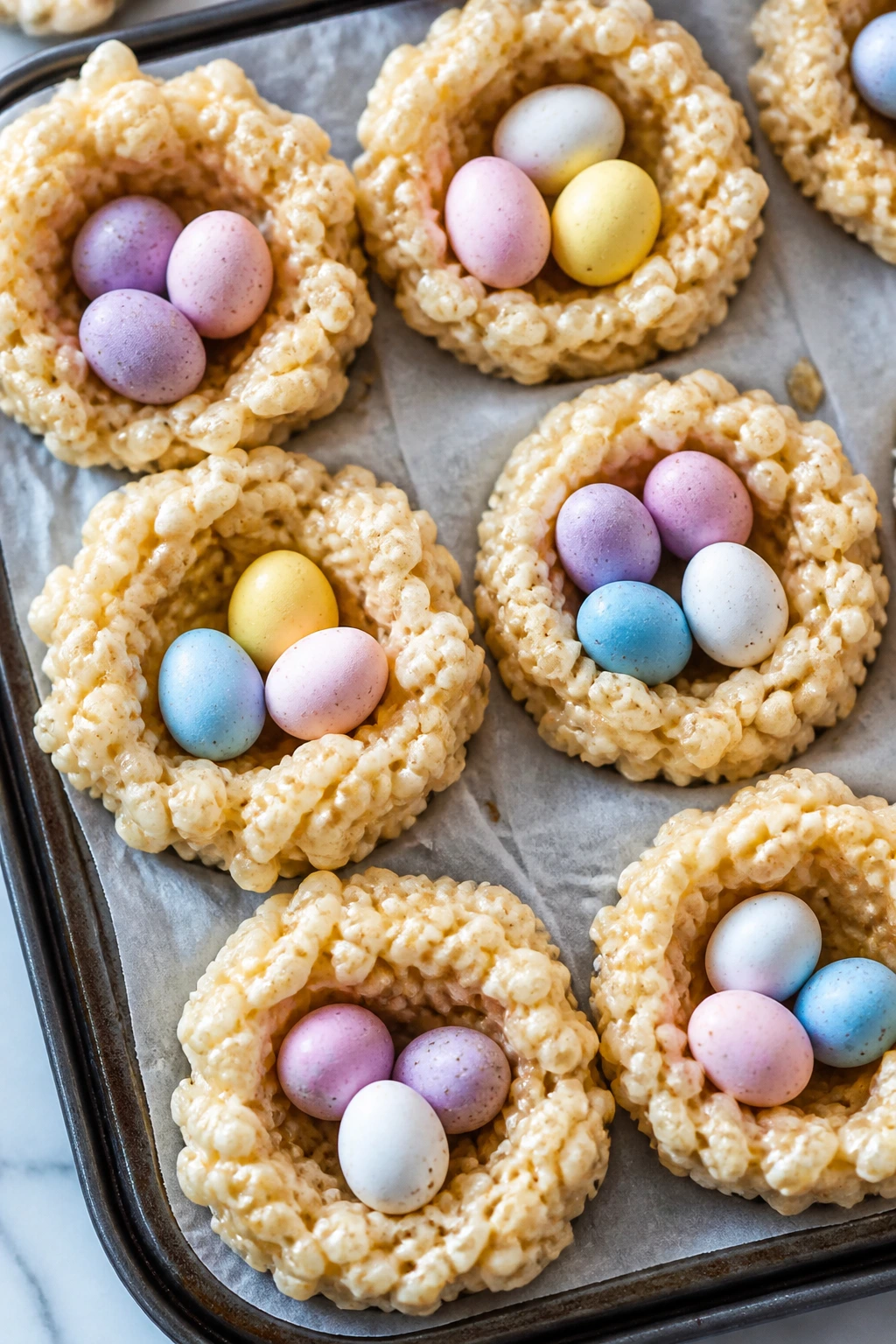 Close-up of marshmallow rice cereal nests with candy eggs in muffin tins