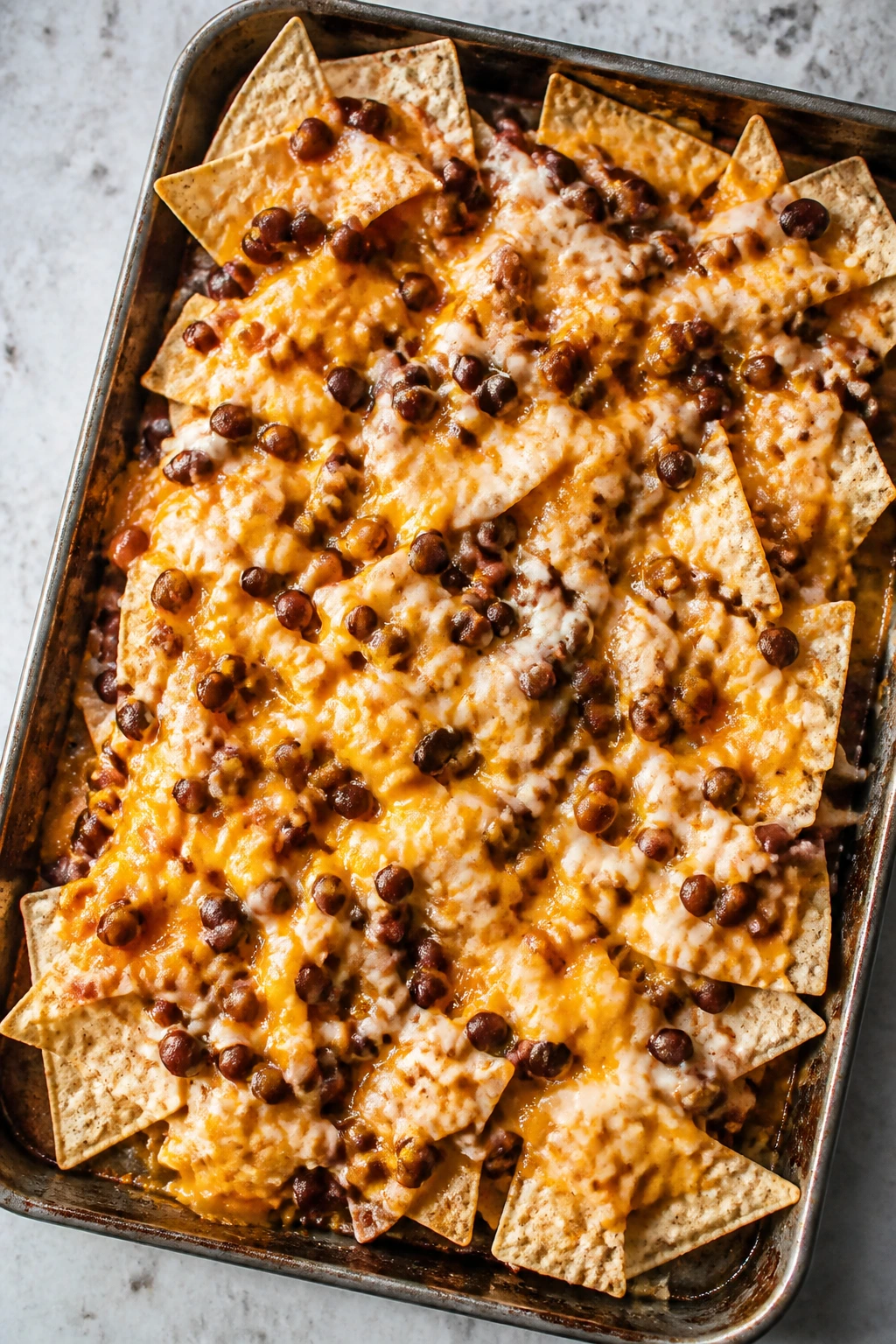 Tray of nachos with beans and melted cheese