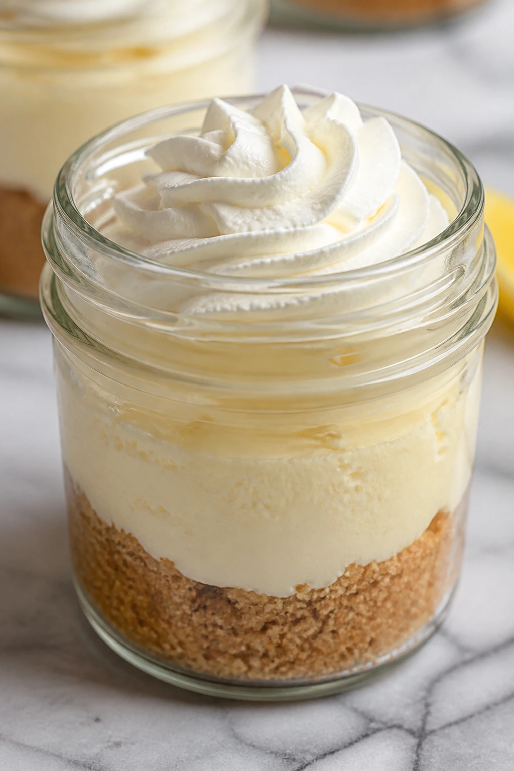Mini cheesecake cup with graham crust and creamy filling on marble surface