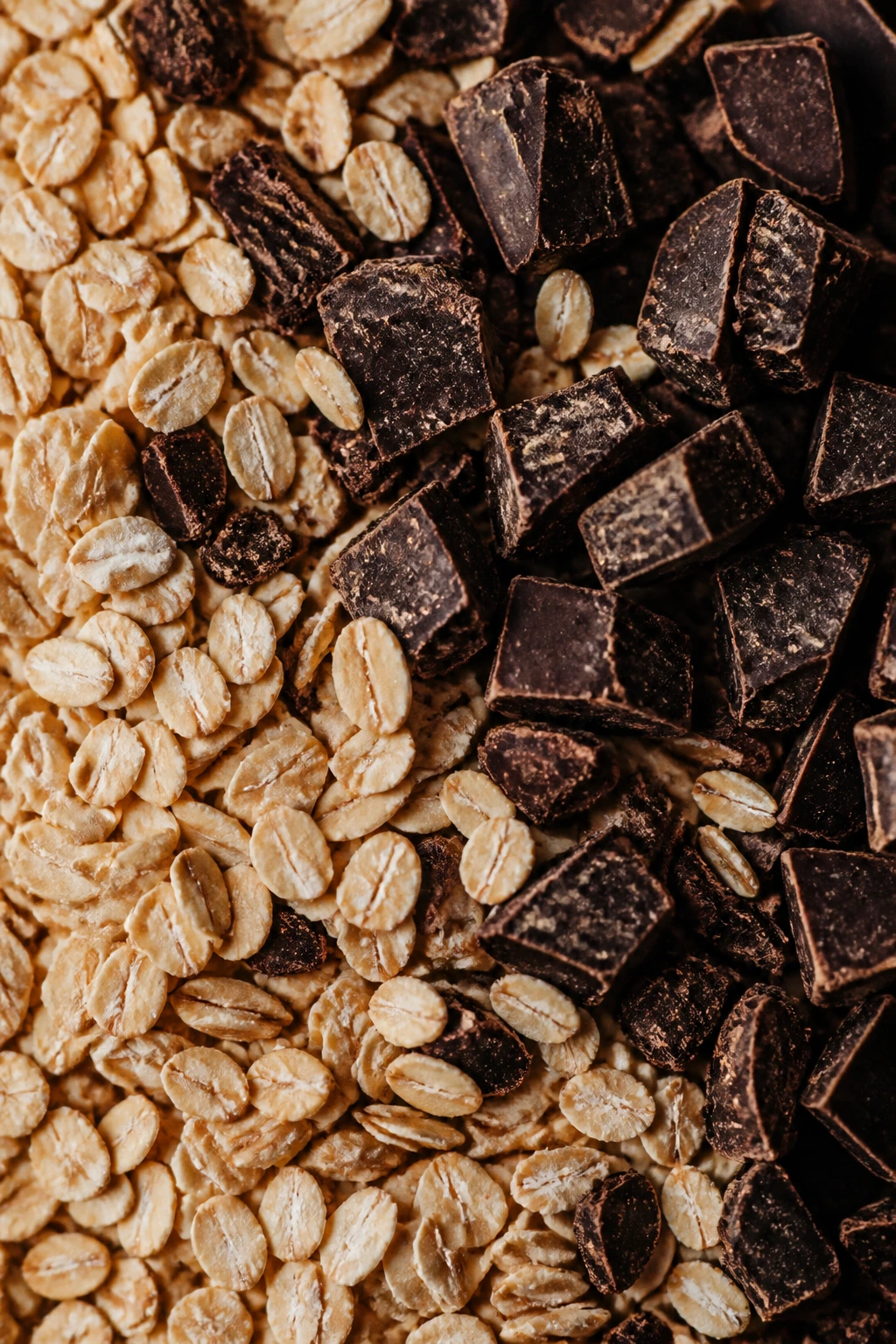 Top-down close-up of oats and dark chocolate on a wooden surface