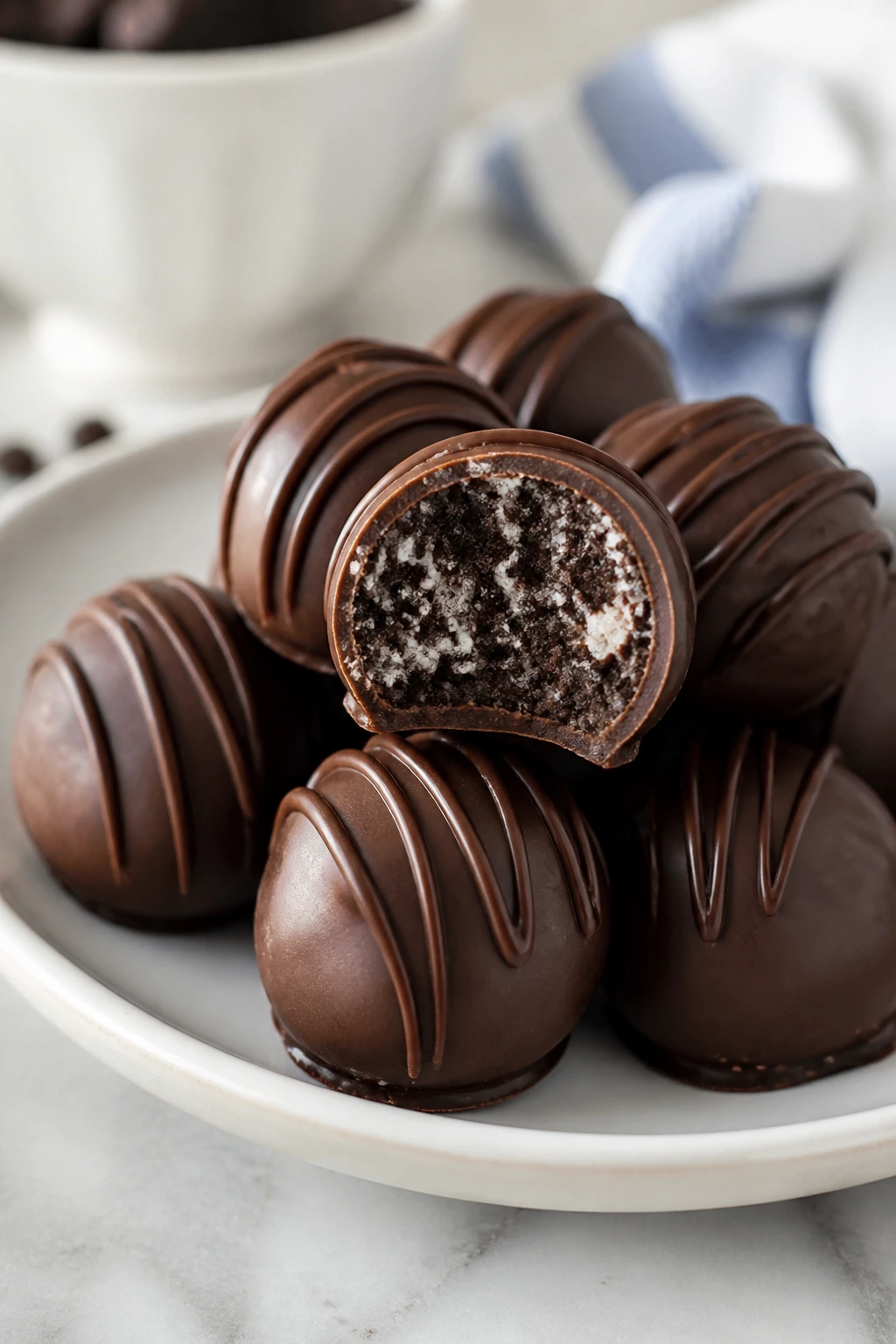Glossy chocolate-coated Oreo Truffle Bites on plate