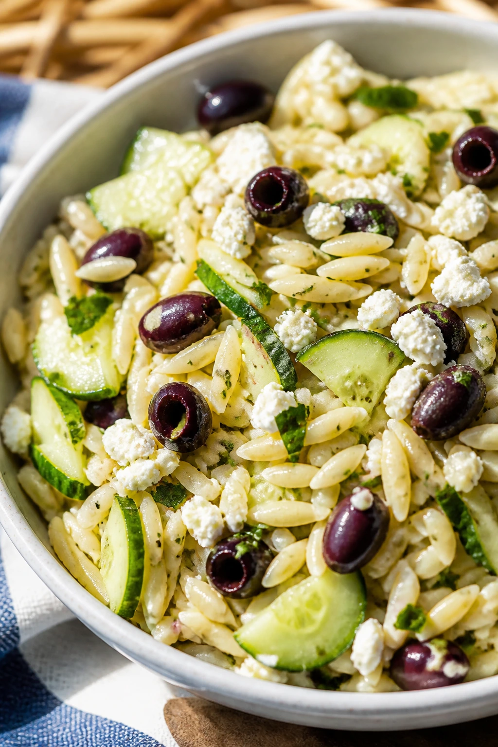 Greek orzo salad with cucumbers olives in a bowl