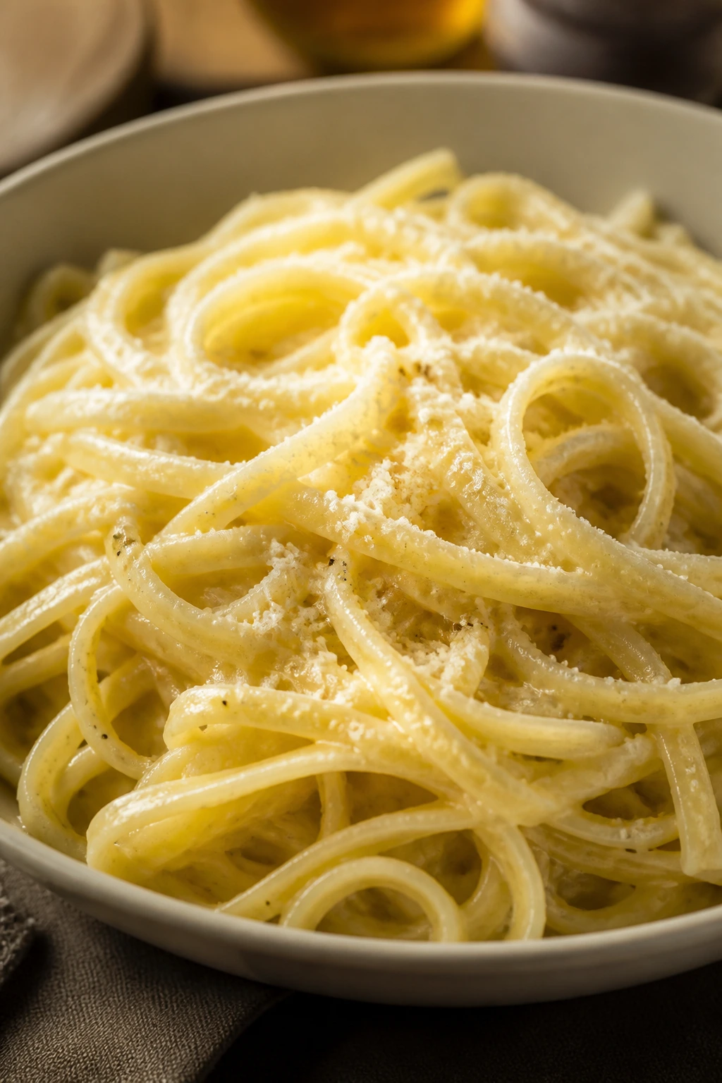 Glossy buttered parmesan noodles in a bowl.