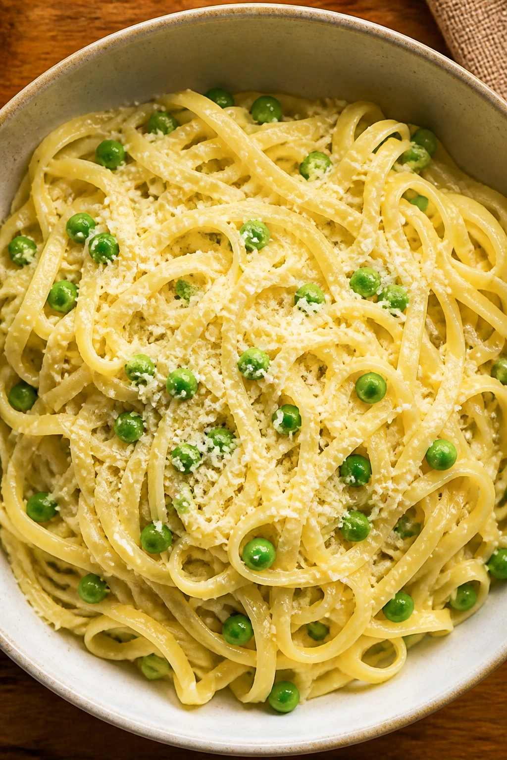 Top-down view of buttered parmesan pasta with peas
