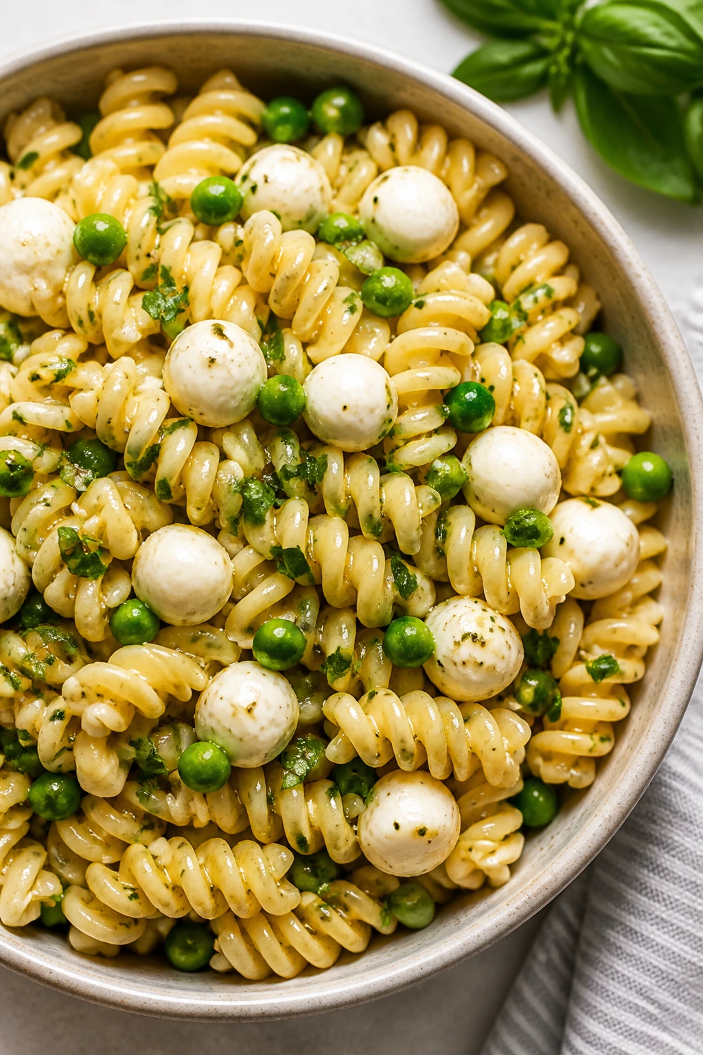 Pasta salad with peas and mozzarella pearls in a bowl