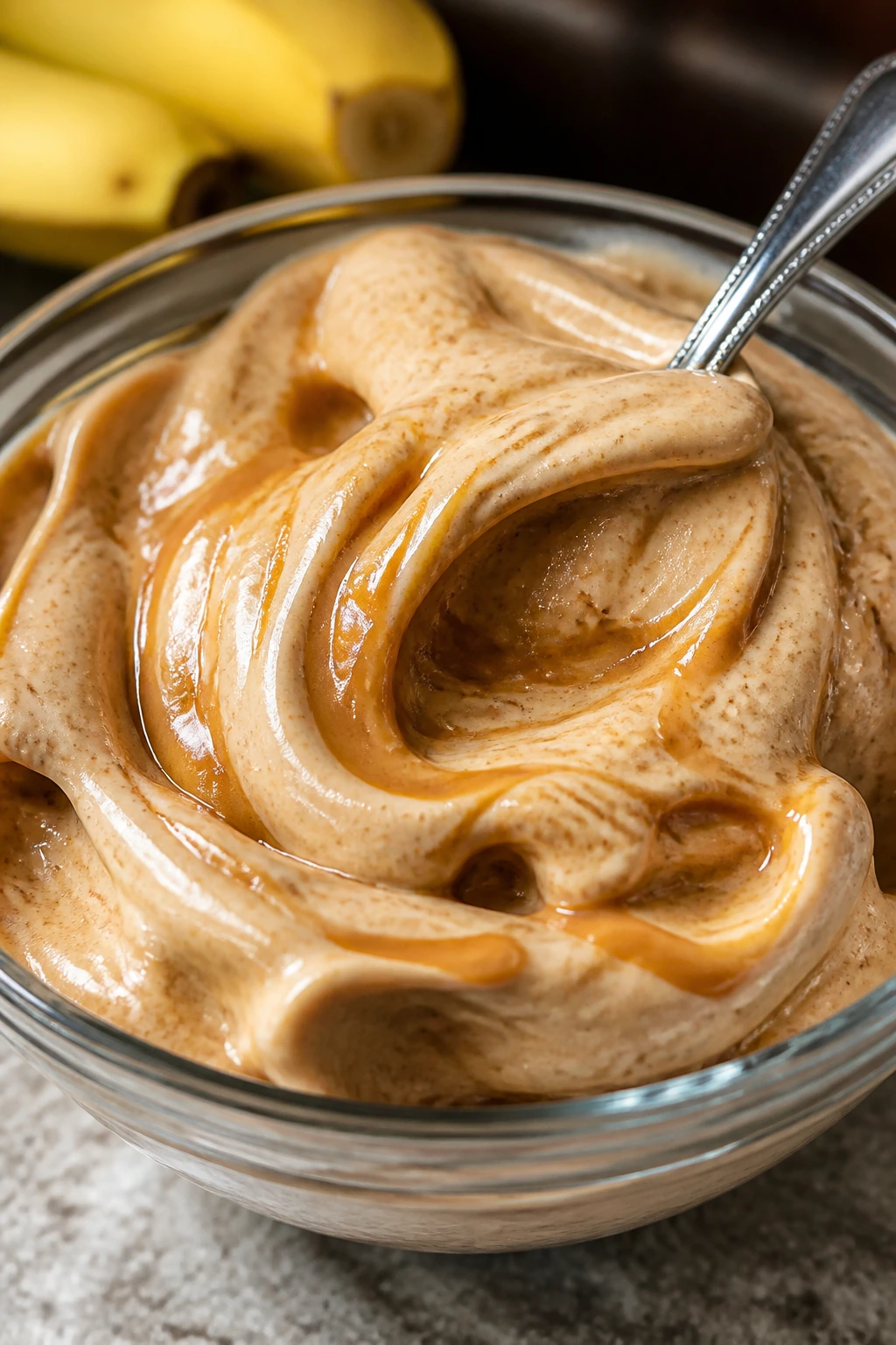 Banana nice cream with peanut butter swirl in glass bowl