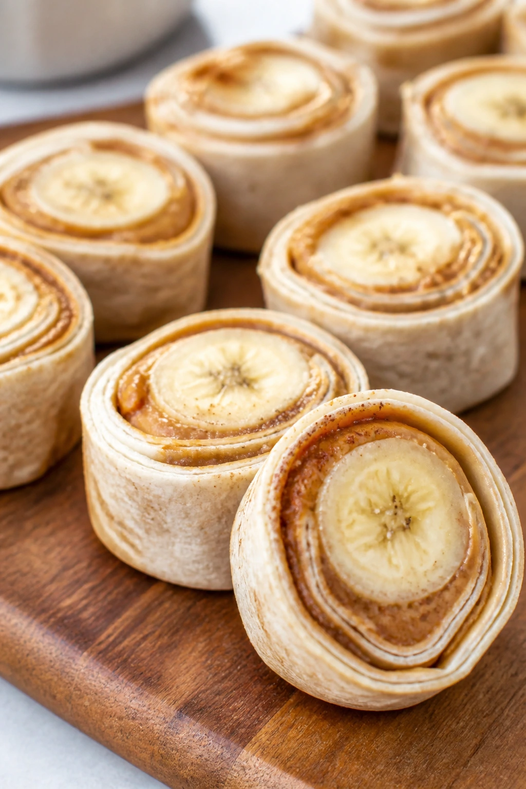 Peanut butter banana sushi rolls sliced into pinwheels on a wooden board