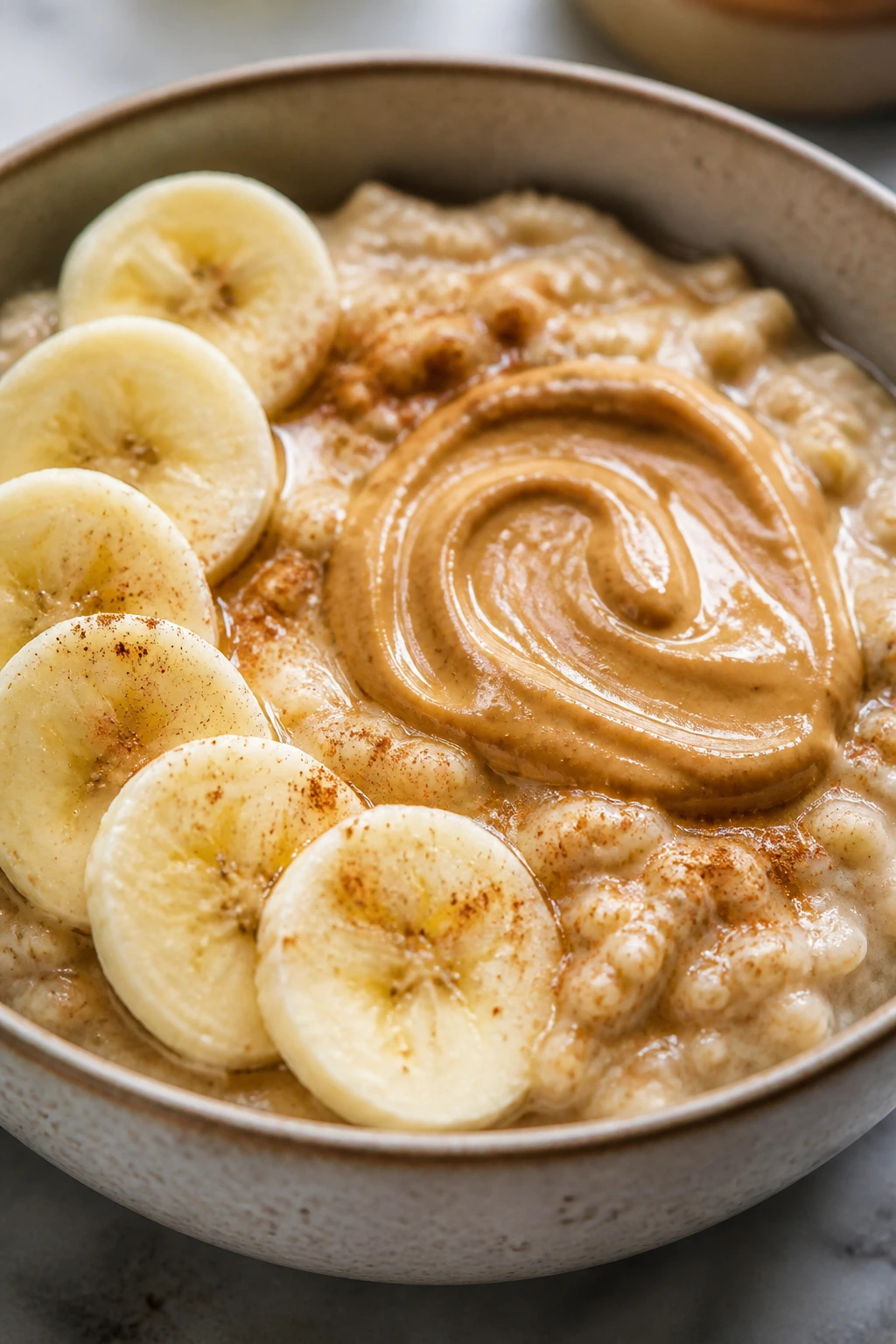 Creamy oatmeal with banana slices and peanut butter swirl