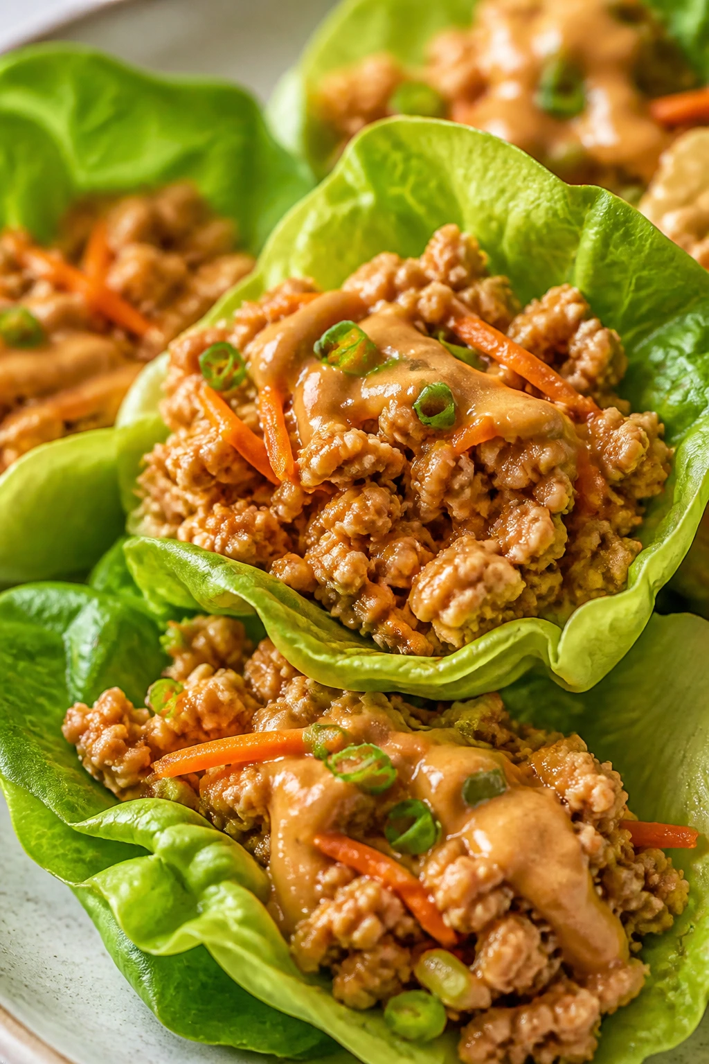 Close-up of Peanut Chicken Lettuce Wraps with lettuce cups and peanut sauce.