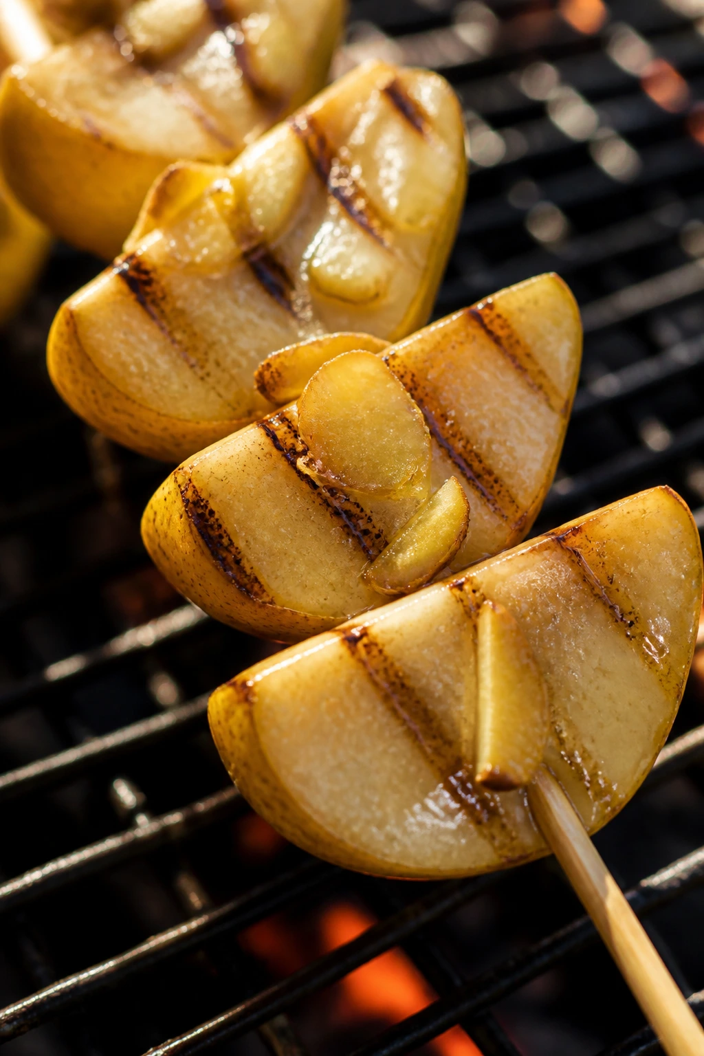Close-up of pear wedges on a skewer with honey-ginger glaze grilled outdoors