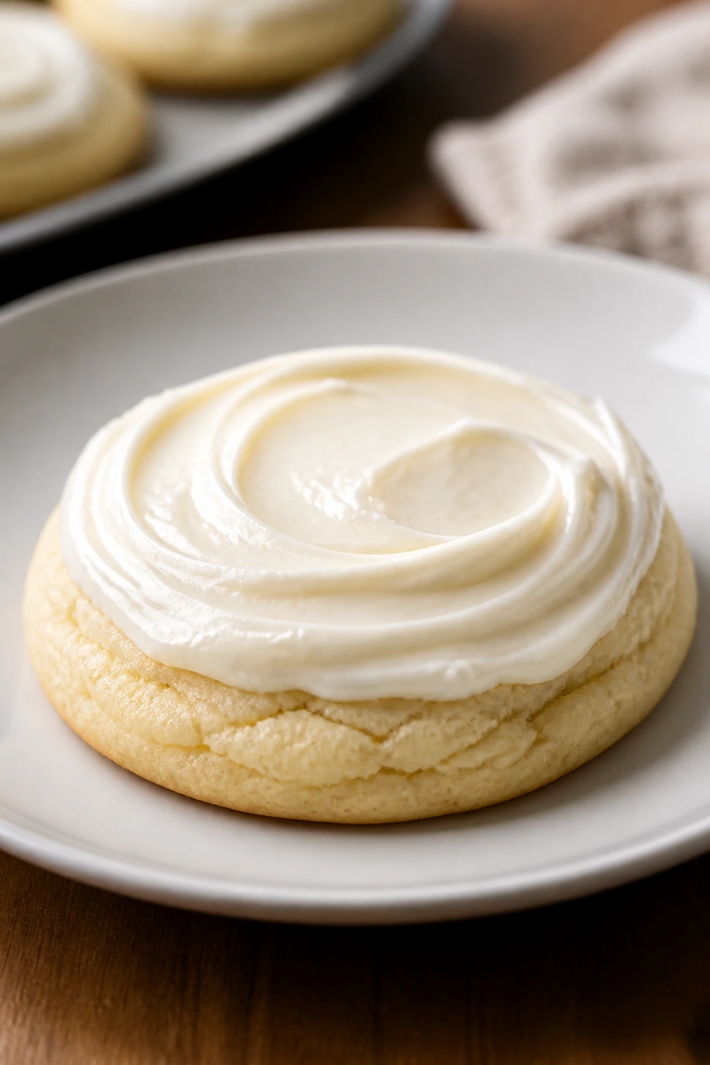 Close-up of a pale pillowy cookie with cream cheese frosting