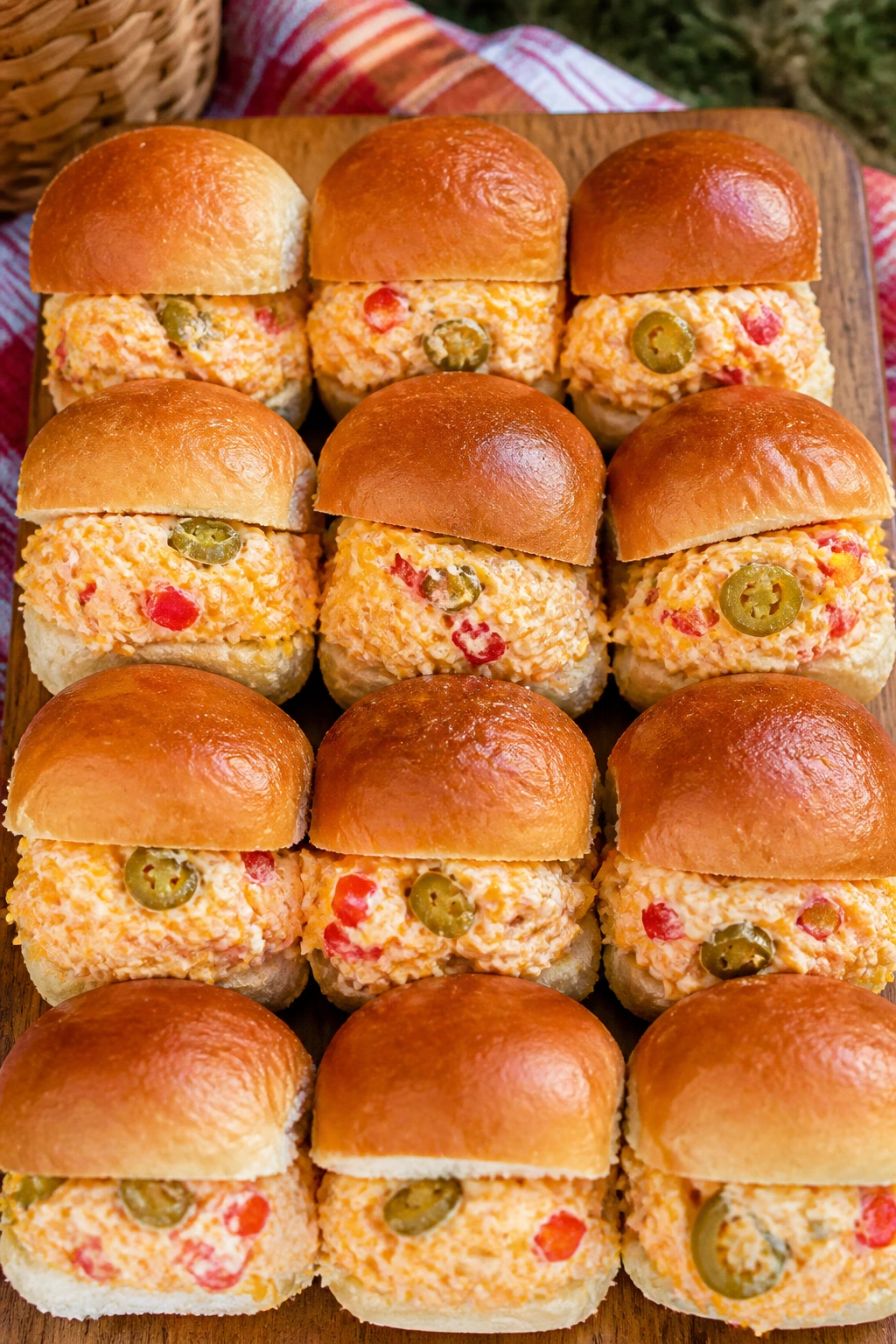 Pimento cheese jalapeño sliders on a picnic board outdoors