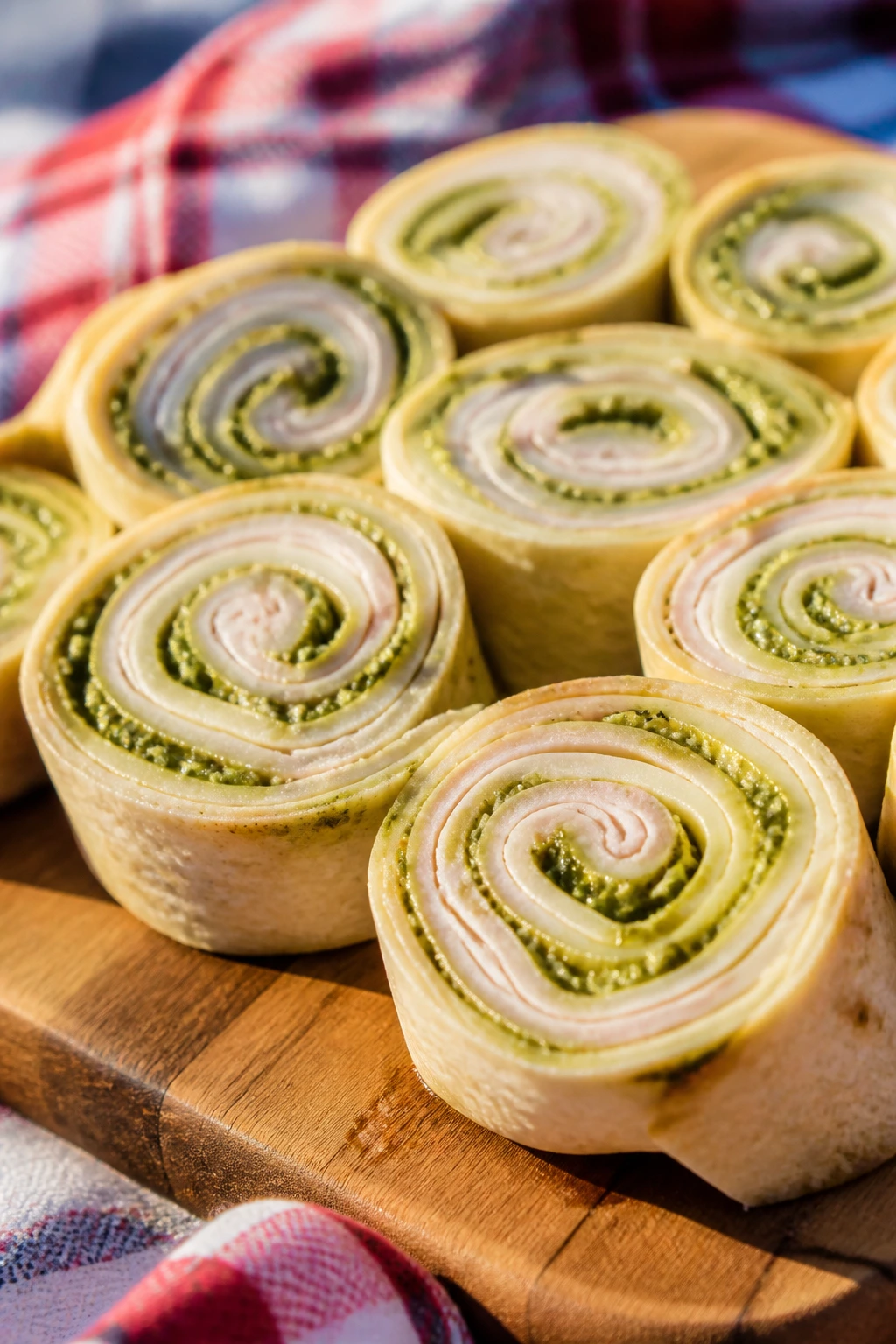 Close-up of turkey Havarti pesto pinwheels on a cutting board outdoors