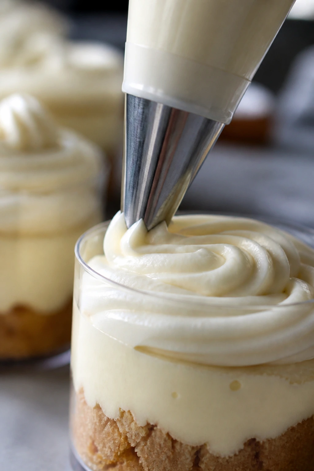 Piping bag extruding frosting onto a mousse cup