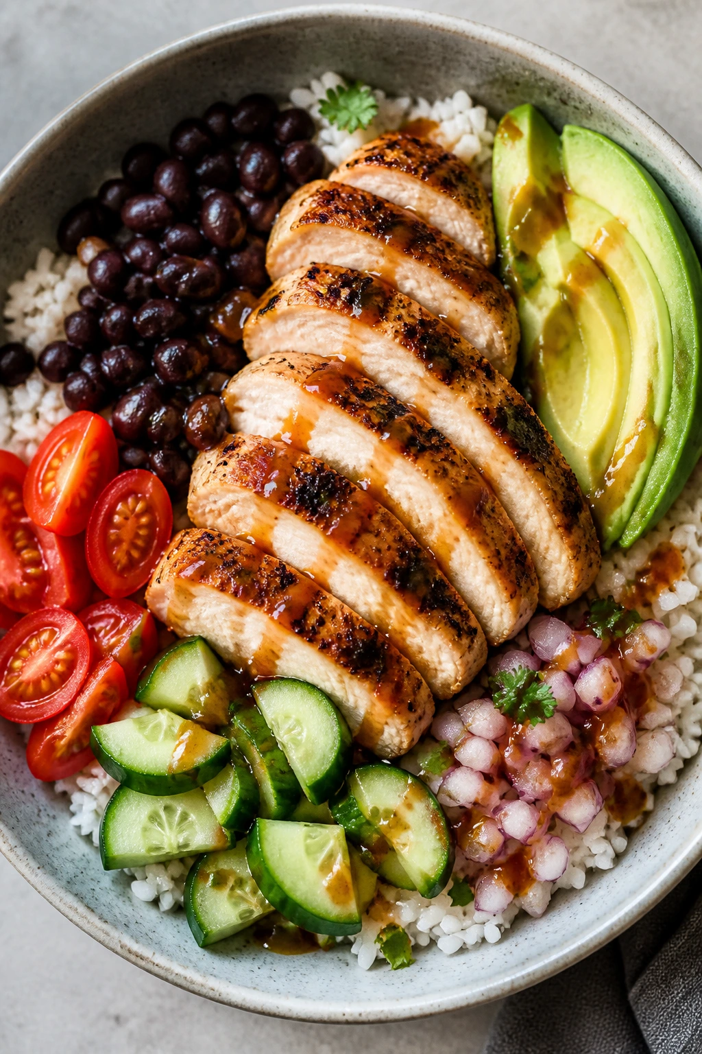 Beautifully plated chicken bowl with rice, beans and toppings