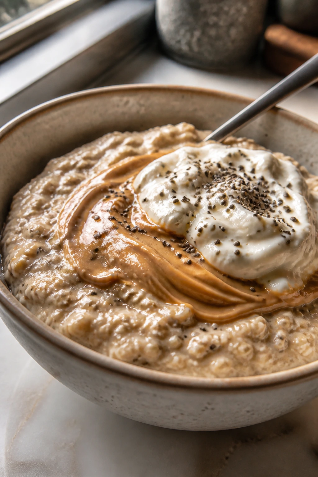 Protein oatmeal bowl with peanut butter swirl and Greek yogurt in a kitchen setting