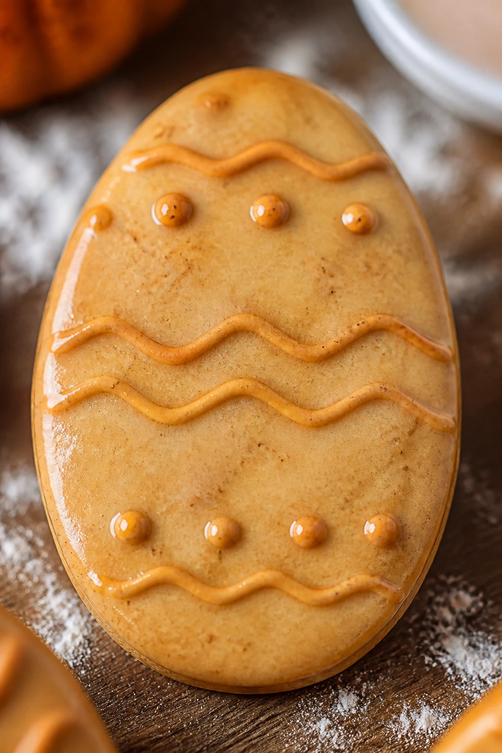 Close-up of a pumpkin spice Easter egg cookie dominating the frame with warm spices visible