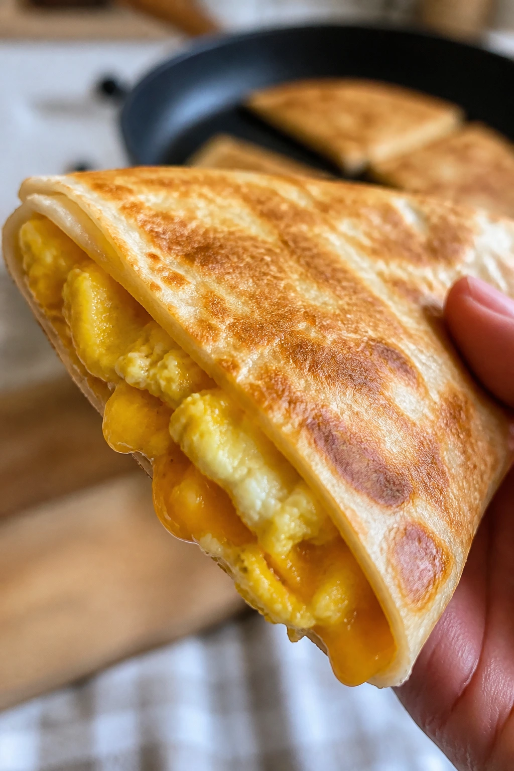 Quesadilla wedge with melted cheese and eggs on a plate