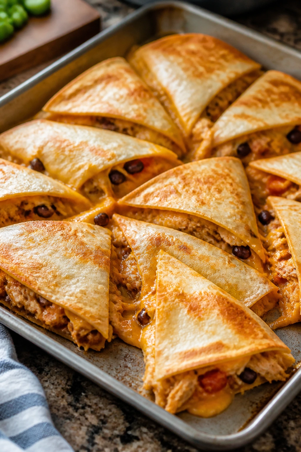 Sheet-pan quesadillas with chicken and cheese, sliced into triangles.