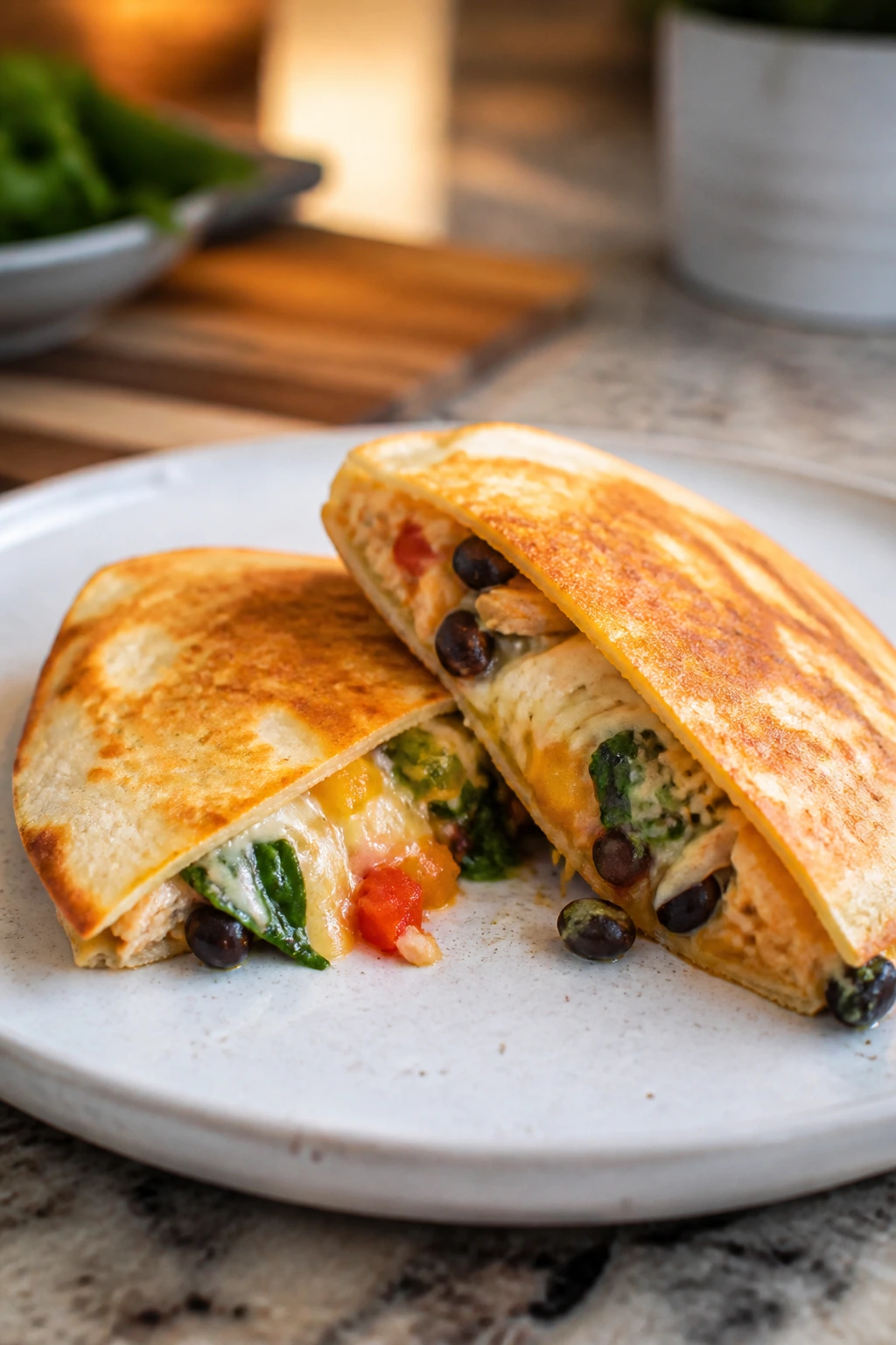 Mini chicken and veggie quesadilla halves on plate.