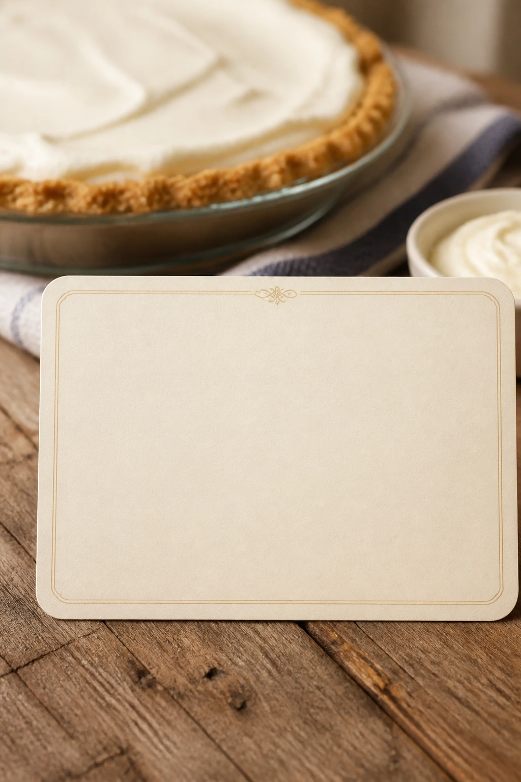 Blank recipe card on a wooden table with pie blurred in the background.