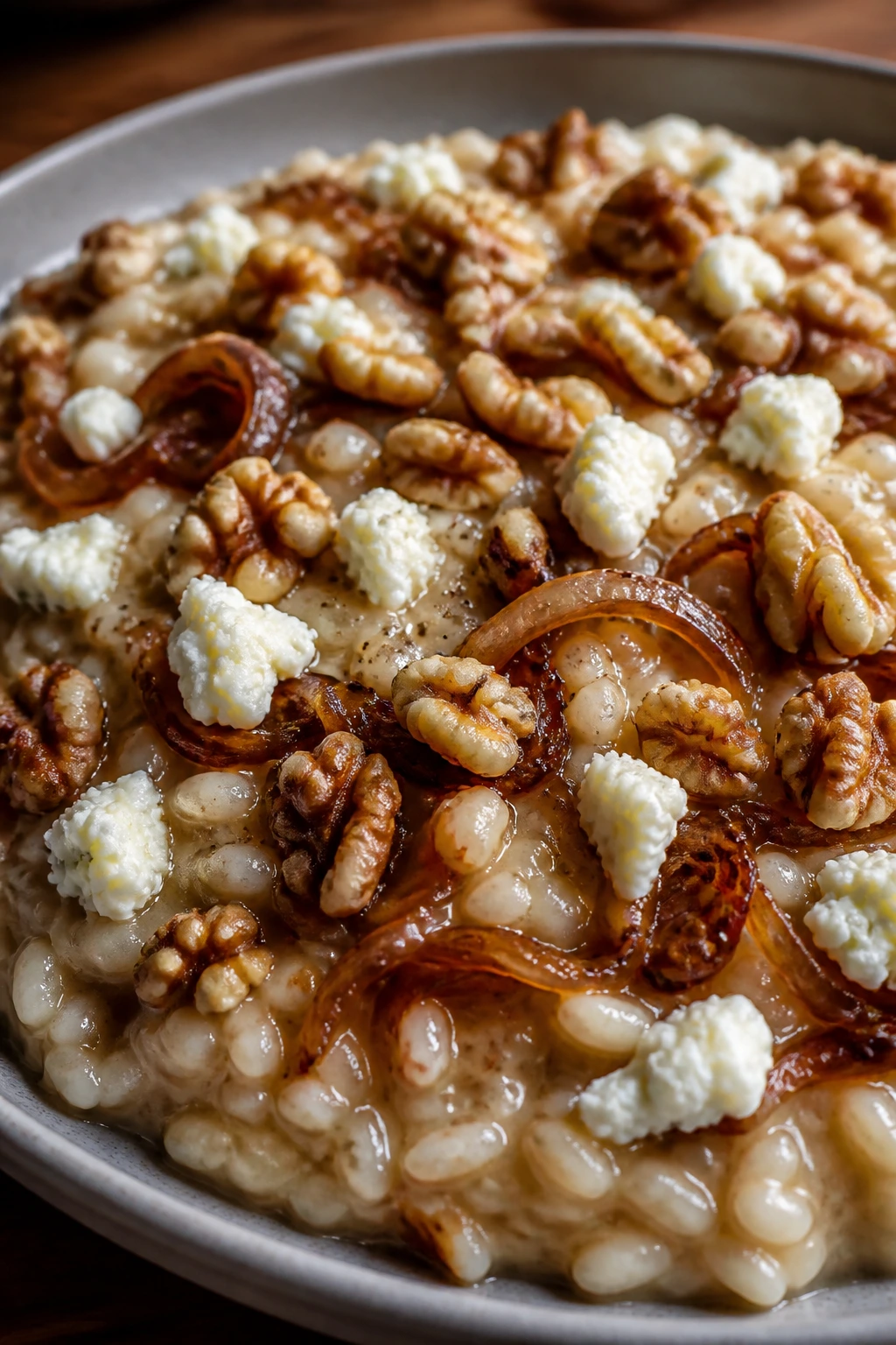 Close-up of caramelized onion risotto with goat cheese and walnuts