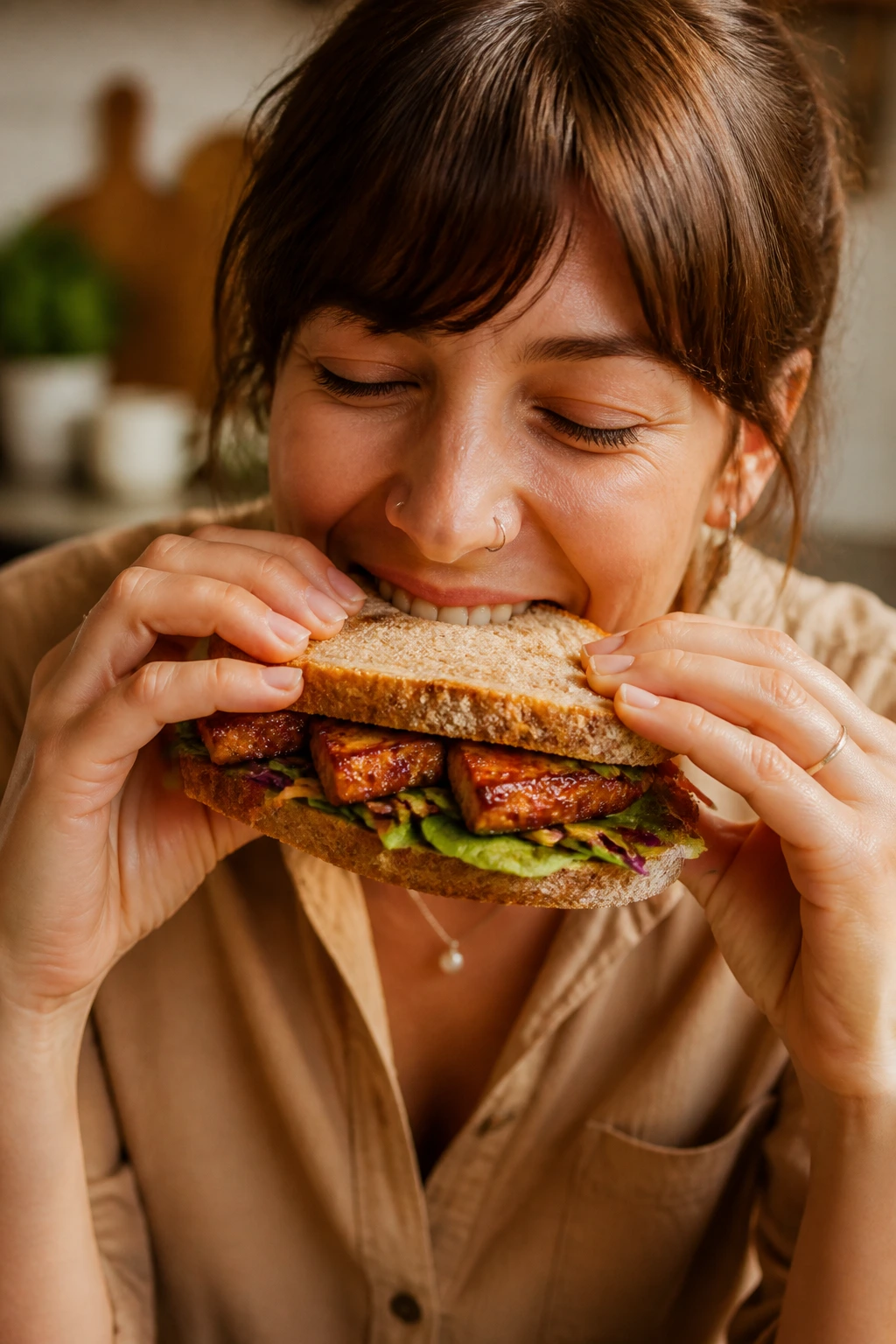 Smiling person eating caramelized tofu sandwich