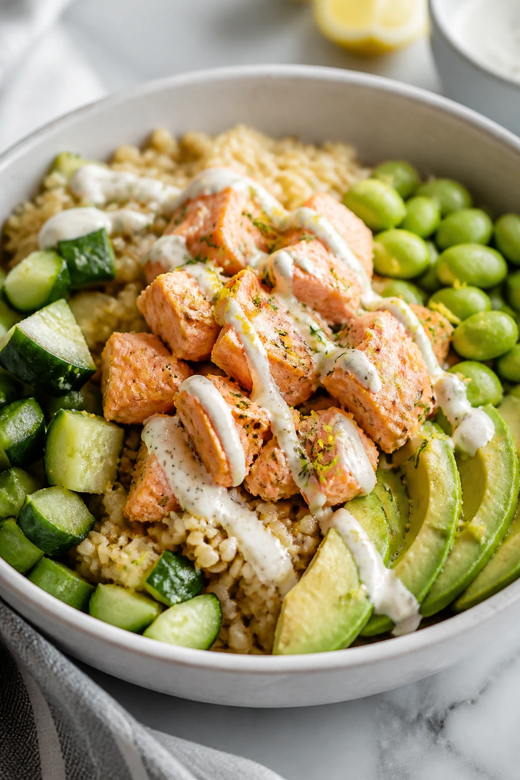Lemon salmon rice bowl with cucumber, edamame, and avocado.