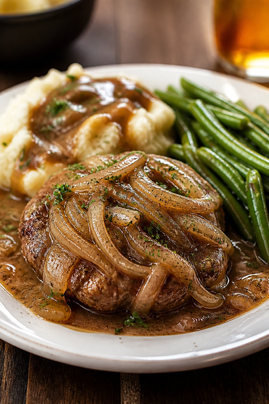 Plated hamburger dinner with gravy over mashed potatoes and vegetables
