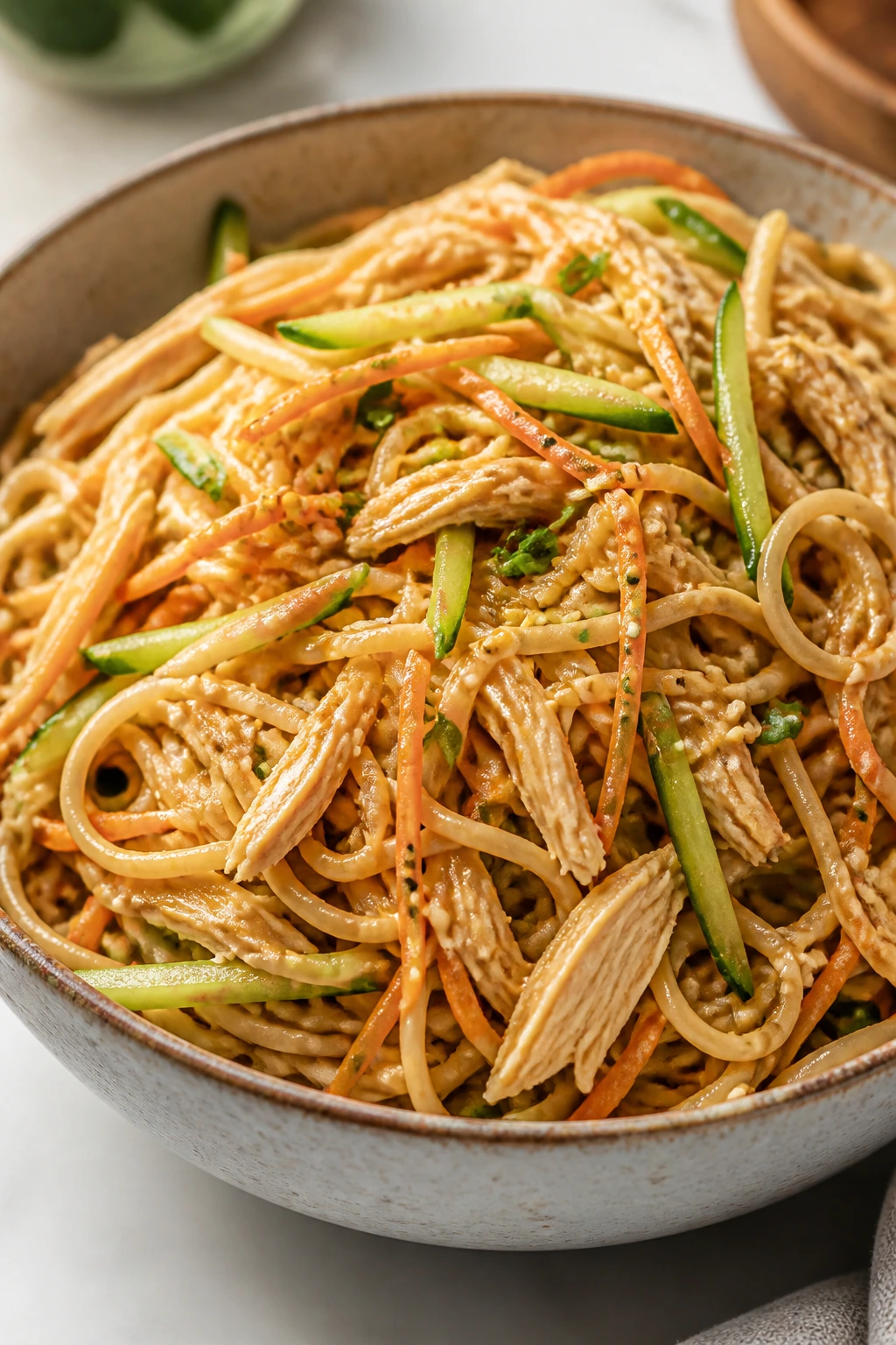 Cold sesame noodle salad with shredded chicken in a bowl