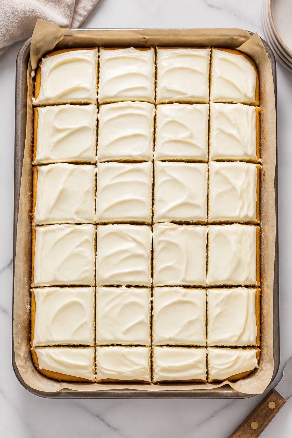 Sheet cake cut into neat squares with cream cheese frosting
