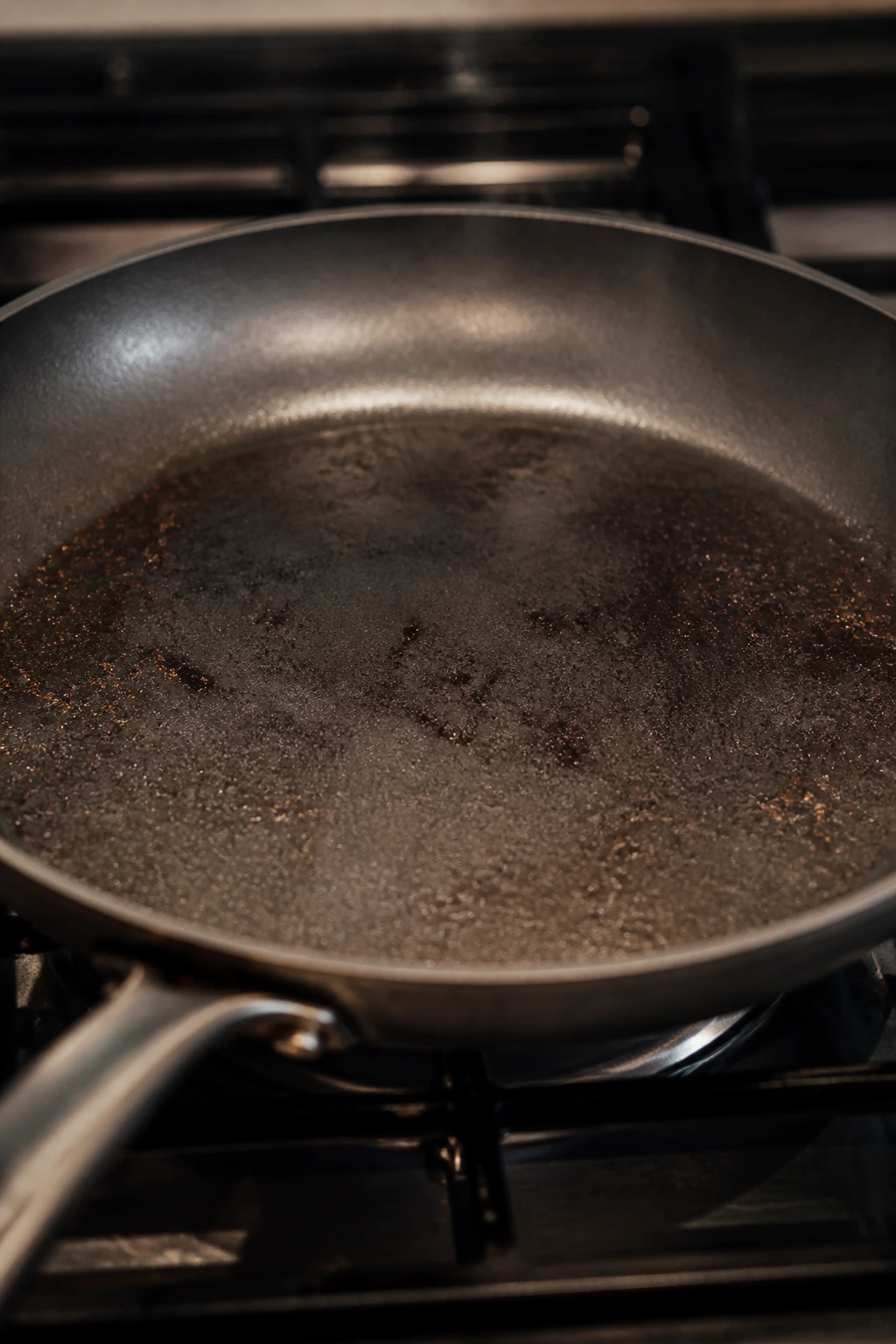 Close-up of a 12-inch skillet on a stove in a warm home kitchen
