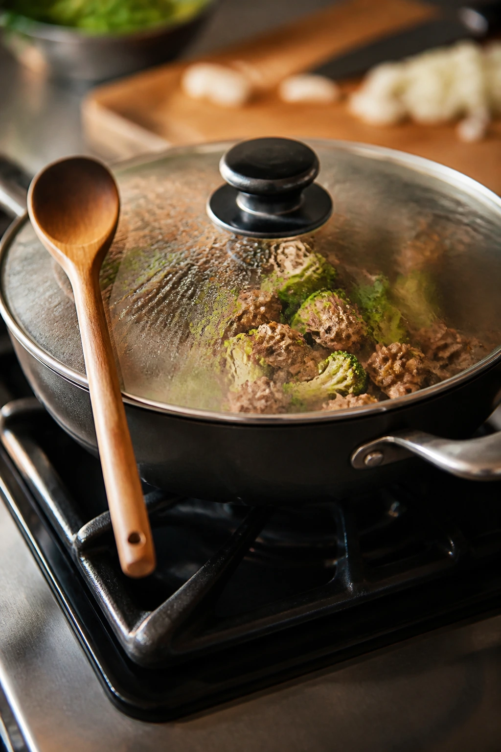 12-inch skillet with lid and wooden spoon on a warm kitchen stove